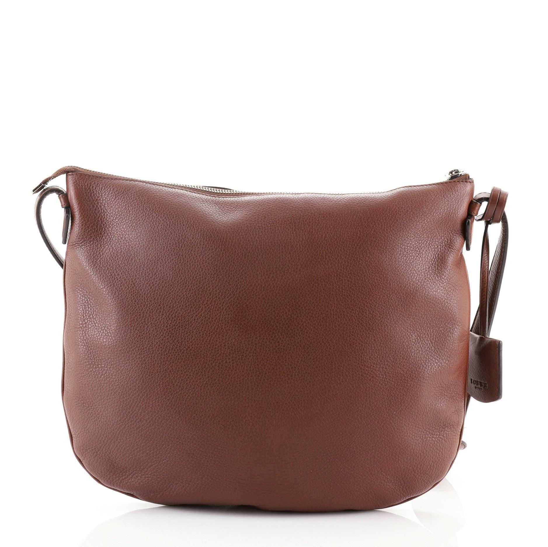 Loewe Heritage Messenger Leder
Braun

Zustand Details: Abnutzungserscheinungen und Schrammen an der Außenseite und den Außenkanten, kleiner Fleck auf der Vorderseite. Risse und Abplatzungen an den Bandwachskanten in der Nähe der Basis, Kratzer an
