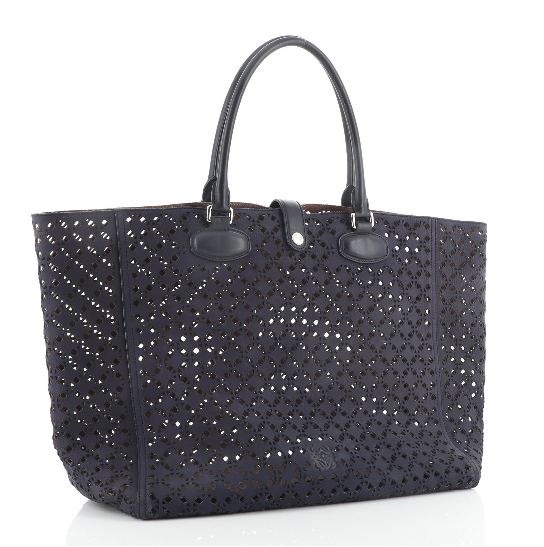 Loewe Leo Shopper Tote Laser Cut Suede Large
Blue

Condition Details: Moderate wear on base, wear on opening, handles, closure trim and pochette. Scuffs on base, minor cracking on base shaper wax edges, scratches on hardware.

51946MSC

Height 