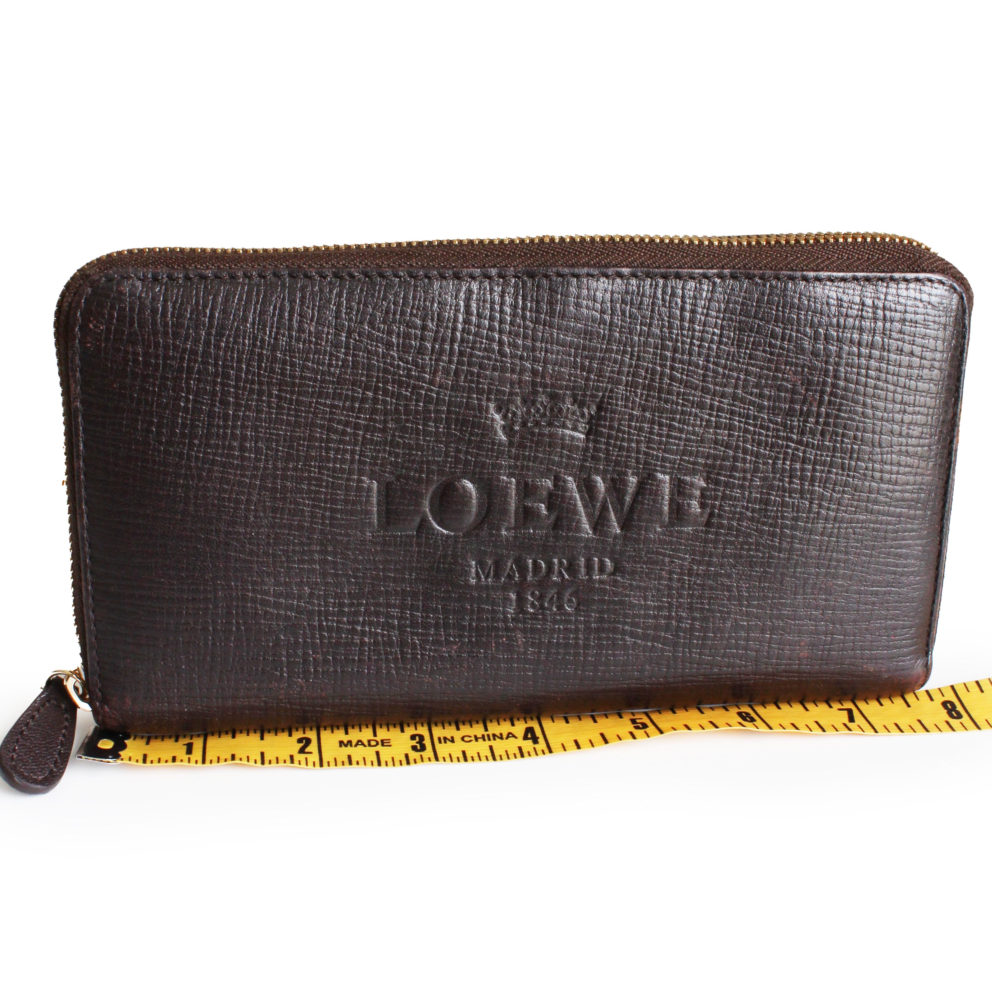 Preowned, vintage zippy wallet by LOEWE, most likely in the 90s.  Made from a textured Epi leather in brown, it features a zip-around closure with leather pull tab. The interior is lined in brown leather with one center zip section, 16 card slots