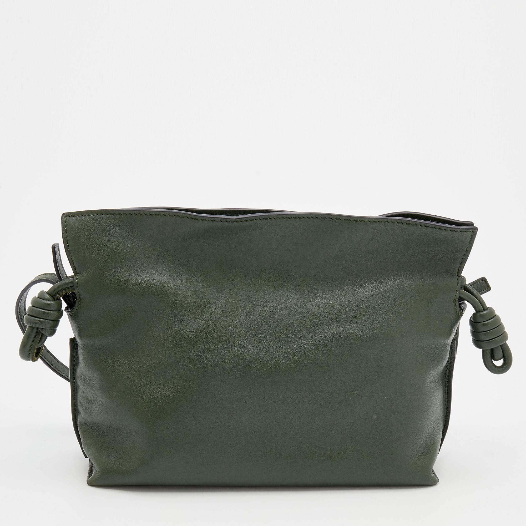 Loewe's Flamenco clutch closes with the help of drawstring pulls in coiled knots like a beautifully wrapped present. This version is in olive green leather. It is lined with suede and accompanied by a shoulder strap.

Includes: Brand Tag