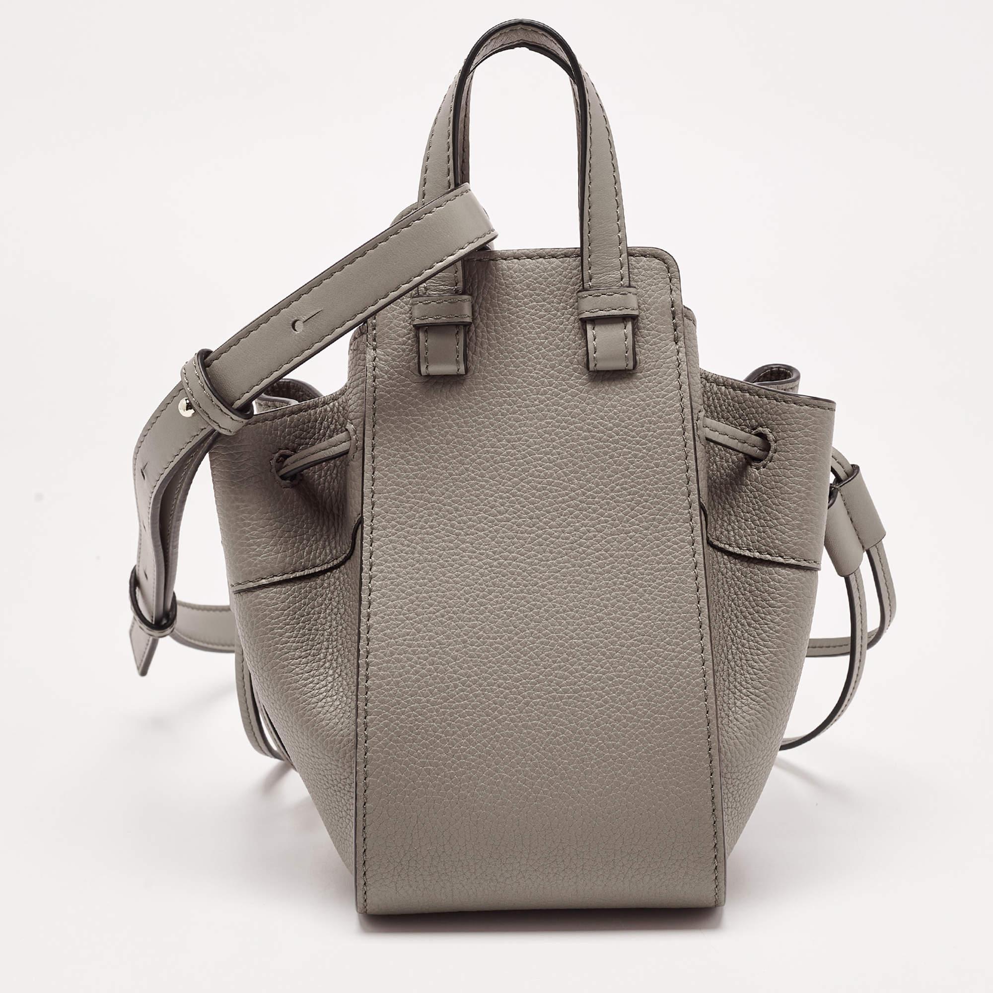 Loewe has been widely recognized for creating pieces that flaunt unique designs and quality craftsmanship. This mini Hammock bag is crafted using leather and has the brand logo embossed on the front. The drawstring closure opens to a canvas-lined