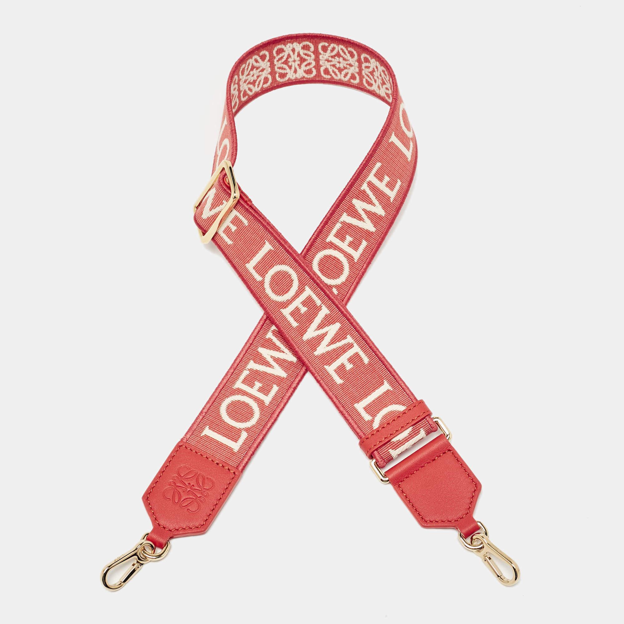 The Loewe bag strap features a striking contrast of orange and beige tones  highlighted by the iconic Anagram motif. Crafted from durable canvas with leather accents  this strap offers both style and versatility. Its adjustable design ensures a