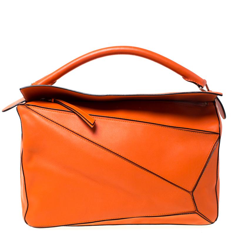 This orange Puzzle bag is crafted from leather in a very artistic way. It comes with a canvas-lined interior, a back zip pocket and the bag is held by a single handle and a shoulder strap. Carry this on all your outings and get ready to feel