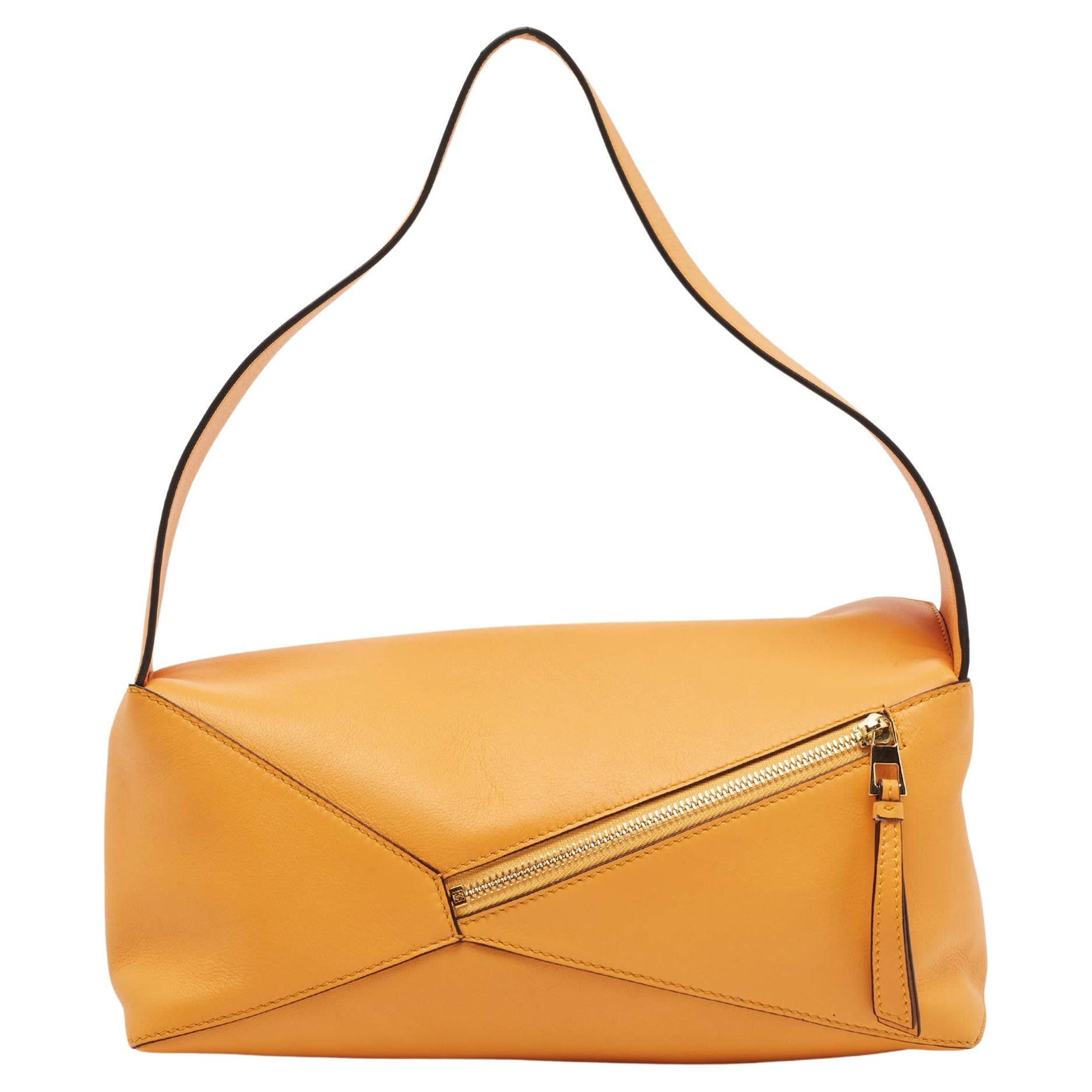 This Puzzle shoulder bag from Loewe will make you go head over heels with its appeal and fine craftsmanship. This stupendous creation is crafted from leather in a very artistic way. It comes with a canvas-lined interior and a back zip pocket, and