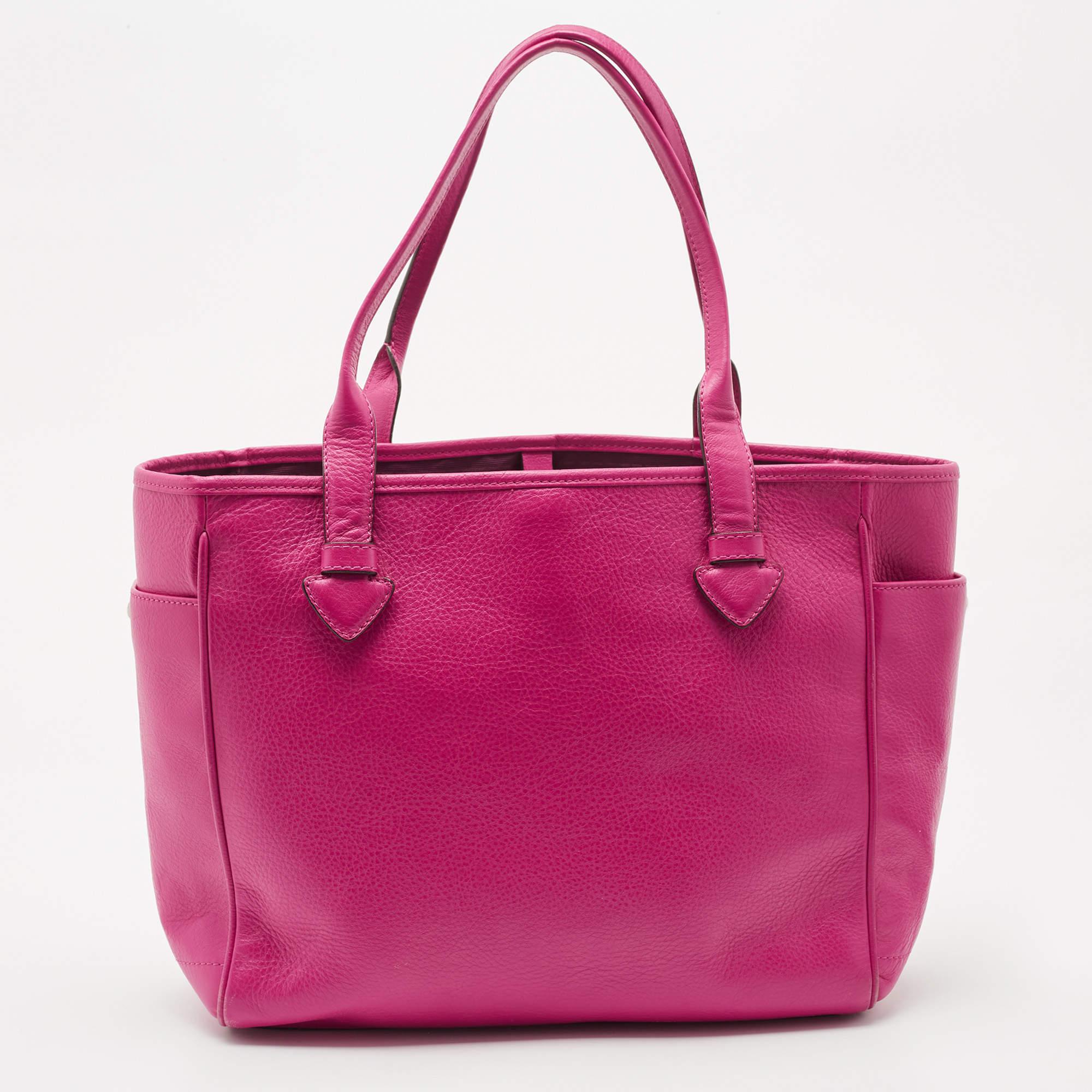 Meant for you to carry all your essentials with ease is this tote by Loewe. Crafted from leather, it comes in a stunning shade of pink. The bag has dual handles, two exterior side pockets, a brand logo, a nylon-lined interior with a zip pocket and