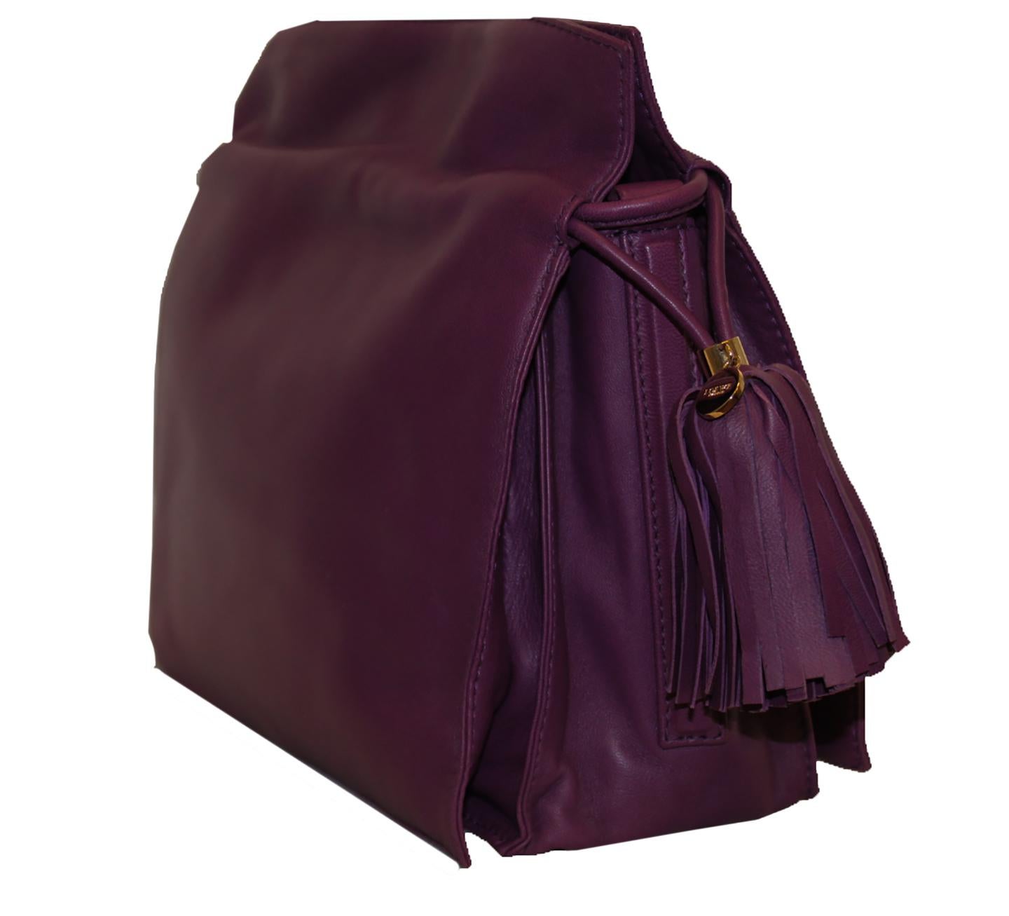 Loewe purple lambskin leather Flamenco bag with top handles incorporates a large tassel on each side with a drawstring for closure.  This bag opens to 3 compartments that are lined in beige linen and cotton.  One of the compartments includes a side
