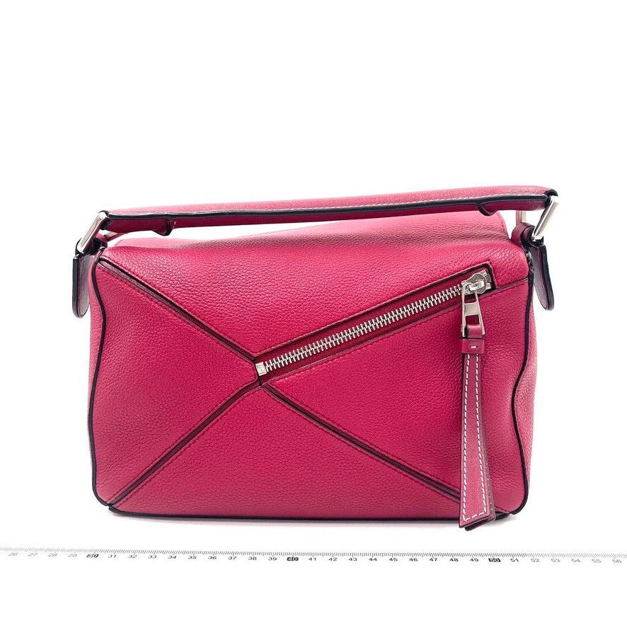 Loewe Puzzle bag small raspberry pink leather
 These are professional photos of the actual bag offered by Luxbags.
 
 Loewe's Puzzle bag is a timeless classic cult piece. Crafted from supple raspberry pink leather and finished with silver hardware