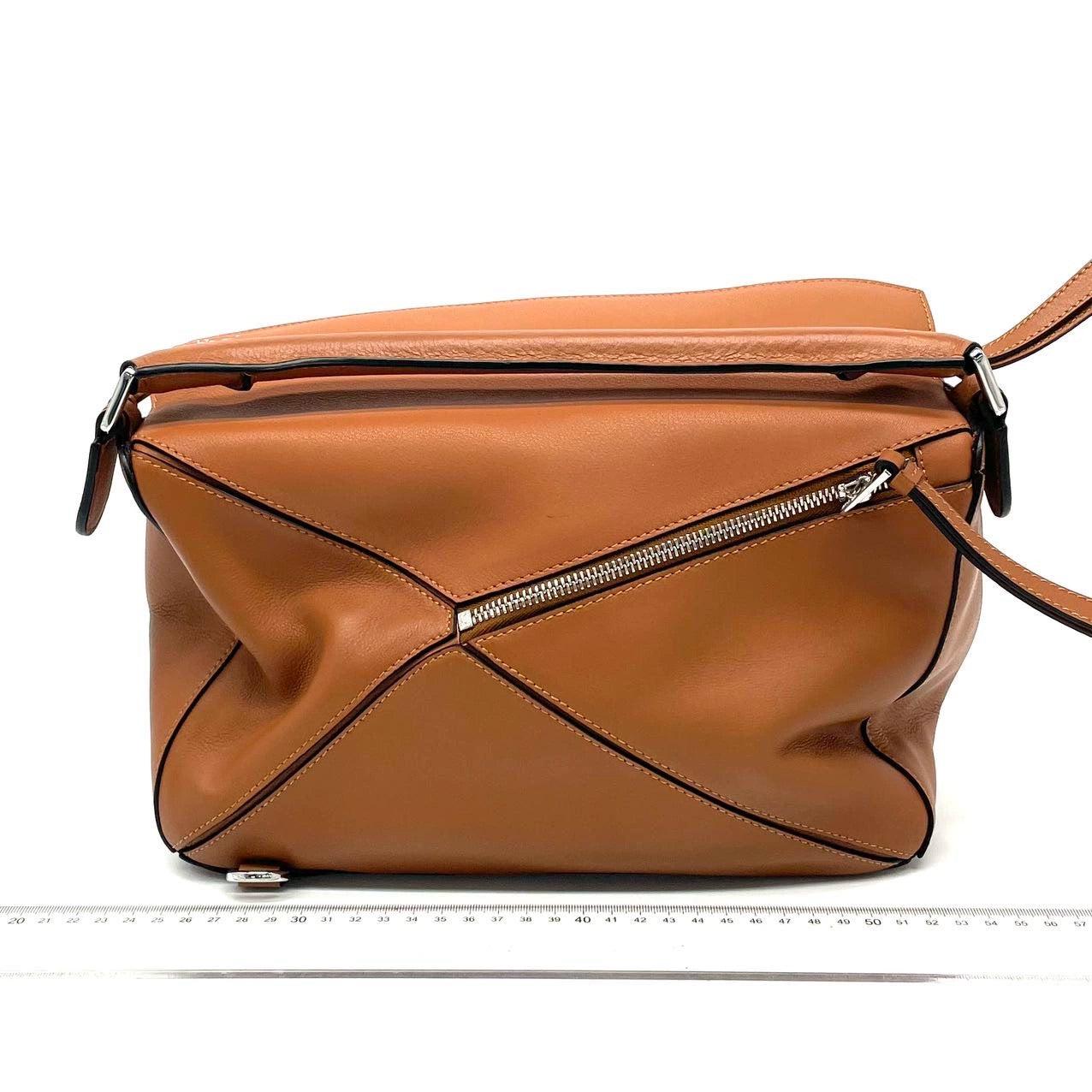 Bolso Loewe Puzzle mediano de piel de becerro color caramelo tostado


El bolso Puzzle de Loewe es una pieza de culto clásica e intemporal. Fabricado en flexible piel de becerro y acabado con herrajes plateados y los característicos paneles
