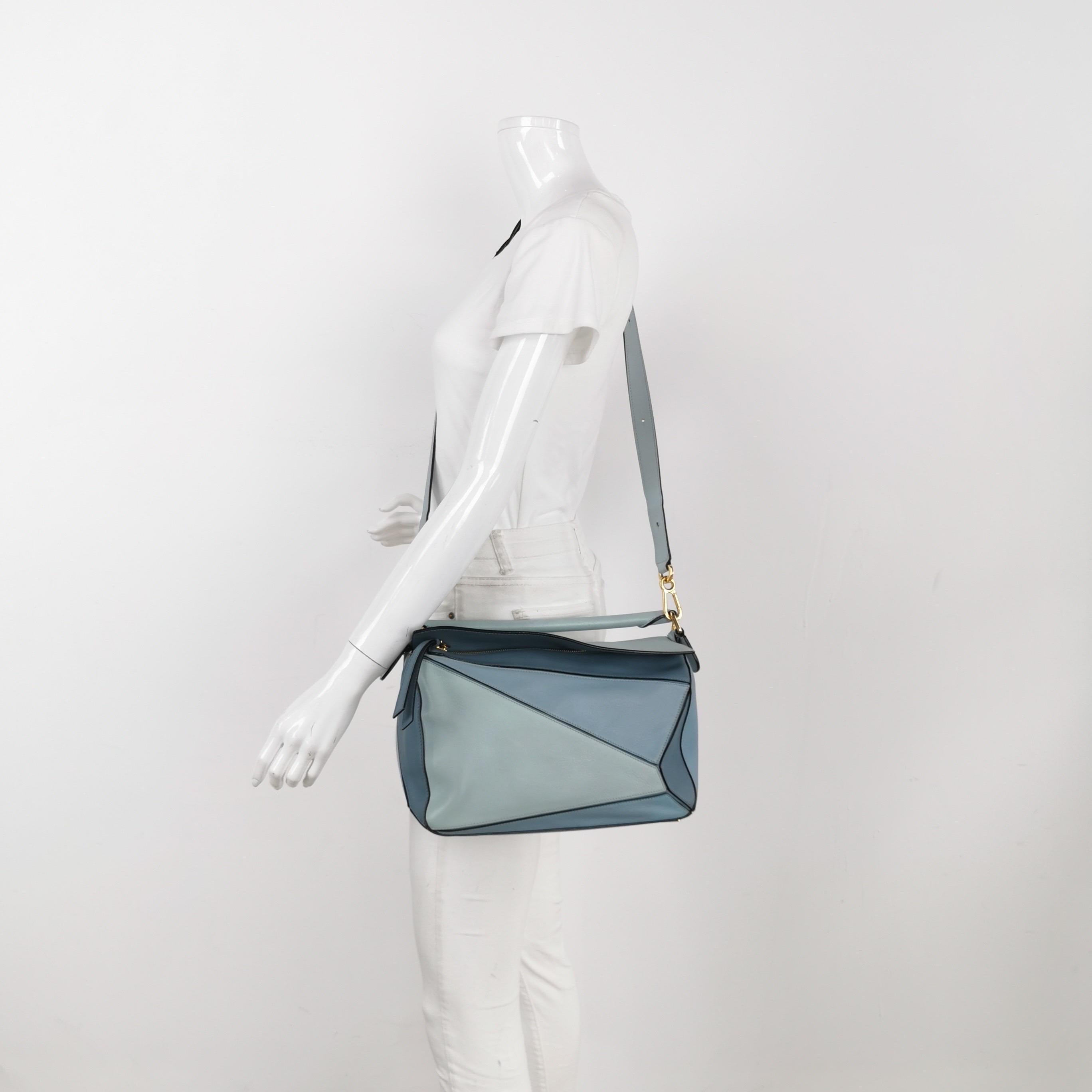 Loewe's Puzzle bag is a timeless classic cult piece. Crafted from supple calfskin leather and finished with silver hardware and signature origami-inspired panels, this bag is versatile and stylish. 

CONDITION: GOOD 

This preloved item is in very