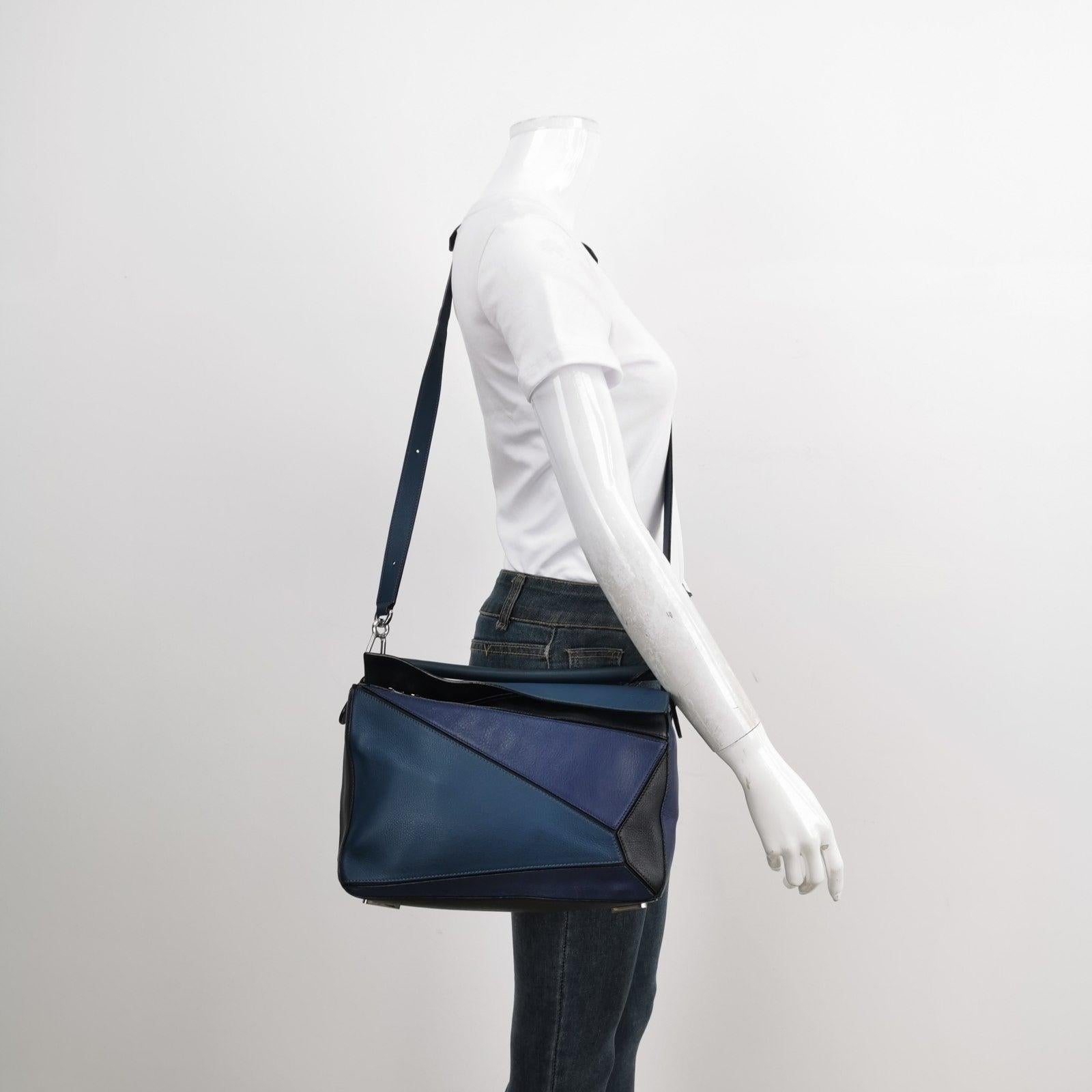 Loewe Puzzle Medium Multicolor Navy Calfskin leather bag These are professional photos of the actual bag offered by Luxbags. Loewe's Puzzle bag is a timeless classic cult piece. Crafted from supple calfskin leather and finished with silver hardware