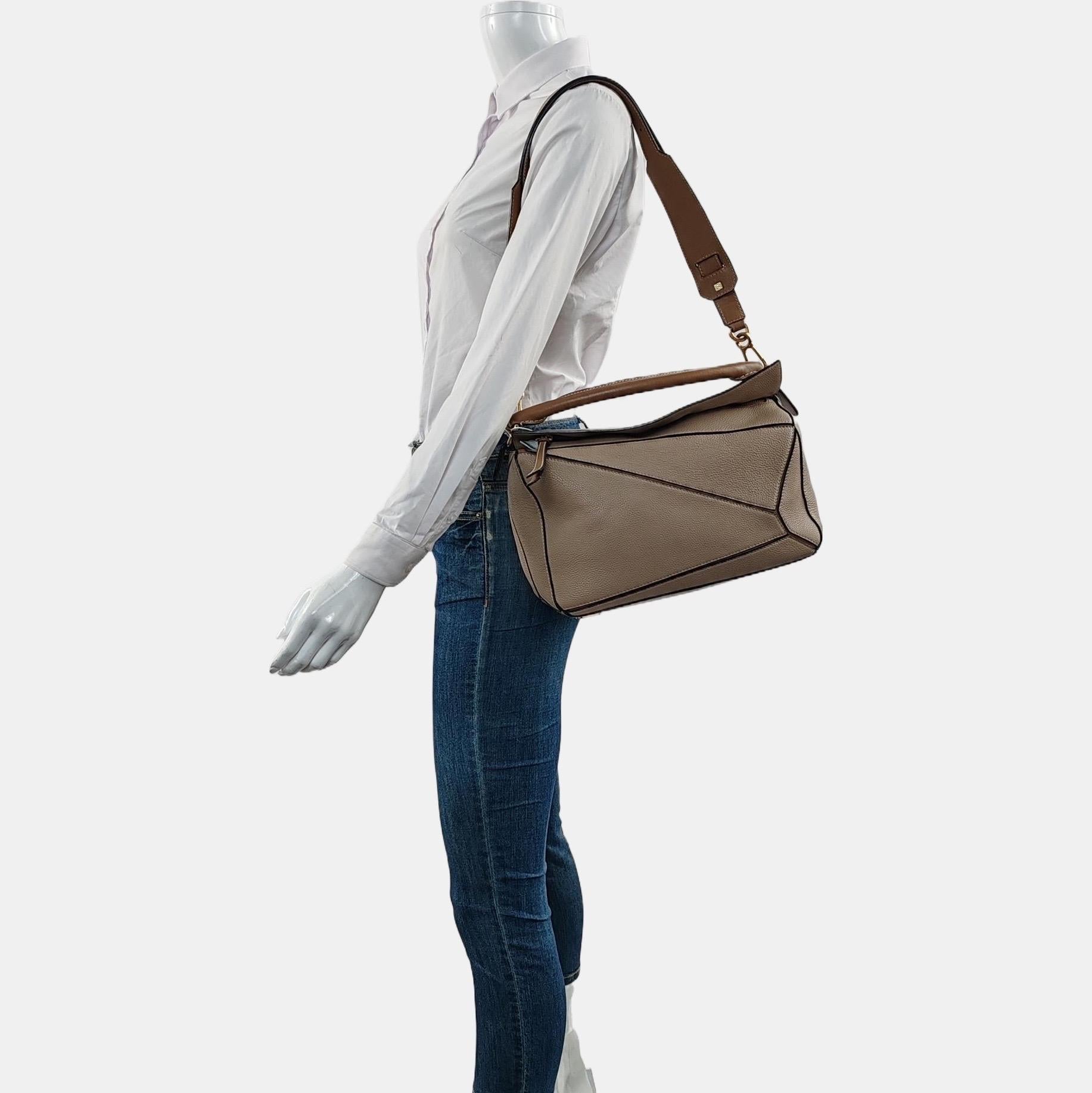 Loewe Puzzle Medium Sand Beige Sac en cuir de veau Brown Strap
Il s'agit de photos professionnelles du sac offert par Luxbags.

Le sac Puzzle de Loewe est un classique intemporel et culte. Confectionné en cuir de veau souple, ce sac est polyvalent