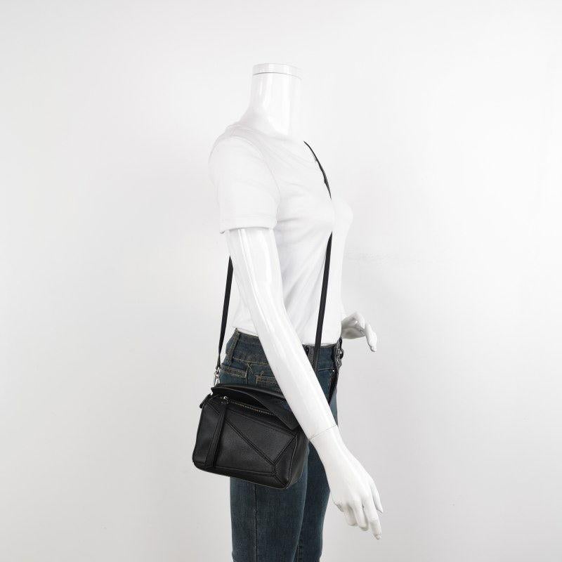 Loewe Puzzle Mini Black Calfskin Leather Crossbody Bag
These are professional photos of the actual bag.
  
  Loewe's Puzzle bag is a timeless classic cult piece. Crafted from supple calfskin leather and finished with silver hardware and signature