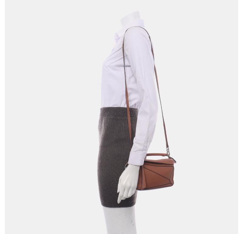 Loewe Puzzle Mini Caramel Tan Calfskin Leather Crossbody Bag
These are professional photos of the actual bag.
  
  Loewe's Puzzle bag is a timeless classic cult piece. Crafted from supple calfskin leather and finished with silver hardware and
