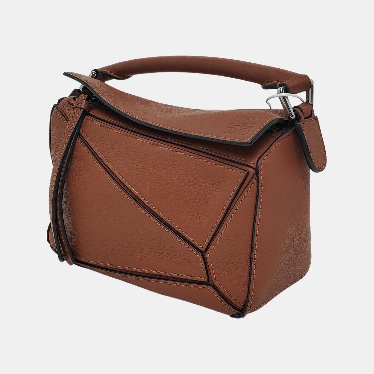 Loewe's Puzzle bag is a timeless classic cult piece. Crafted from supple calfskin leather and finished with silver hardware and signature origami-inspired panels, this bag is versatile and stylish. 

CONDITION:EXCELLENT

This preloved authentic item