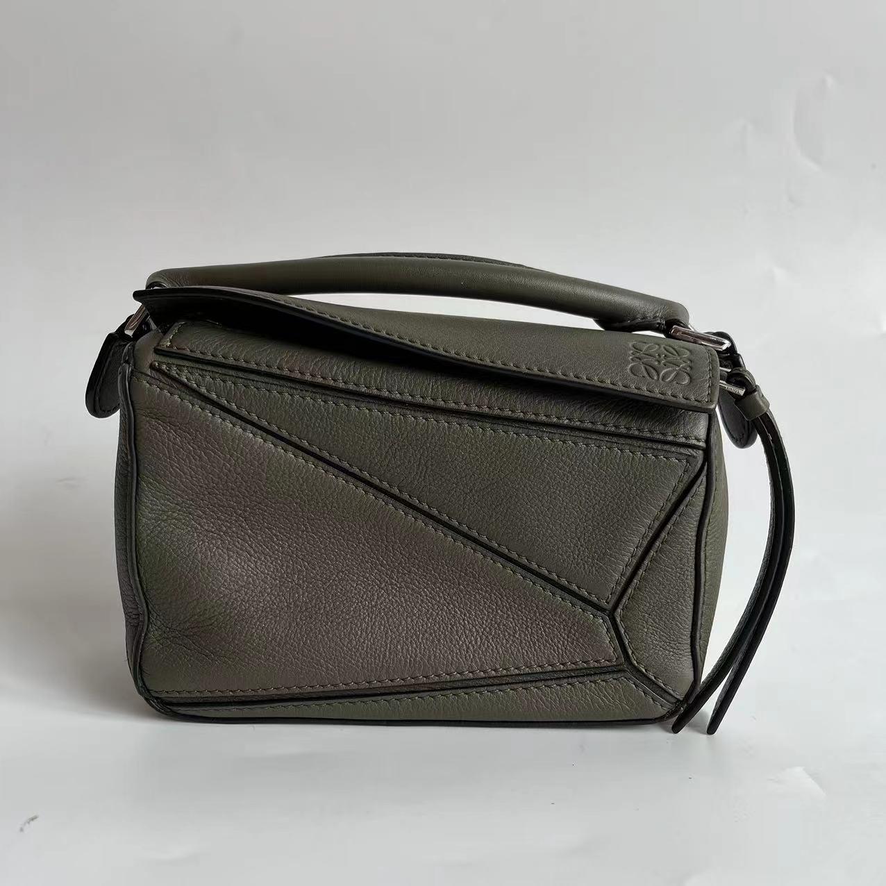 Loewe Puzzle Mini Olive Green Sac à bandoulière en cuir de veau
Il s'agit de photos professionnelles du sac offert par Luxbags.

Le sac Puzzle de Loewe est un classique intemporel et culte. Confectionné en cuir de veau souple, ce sac est polyvalent