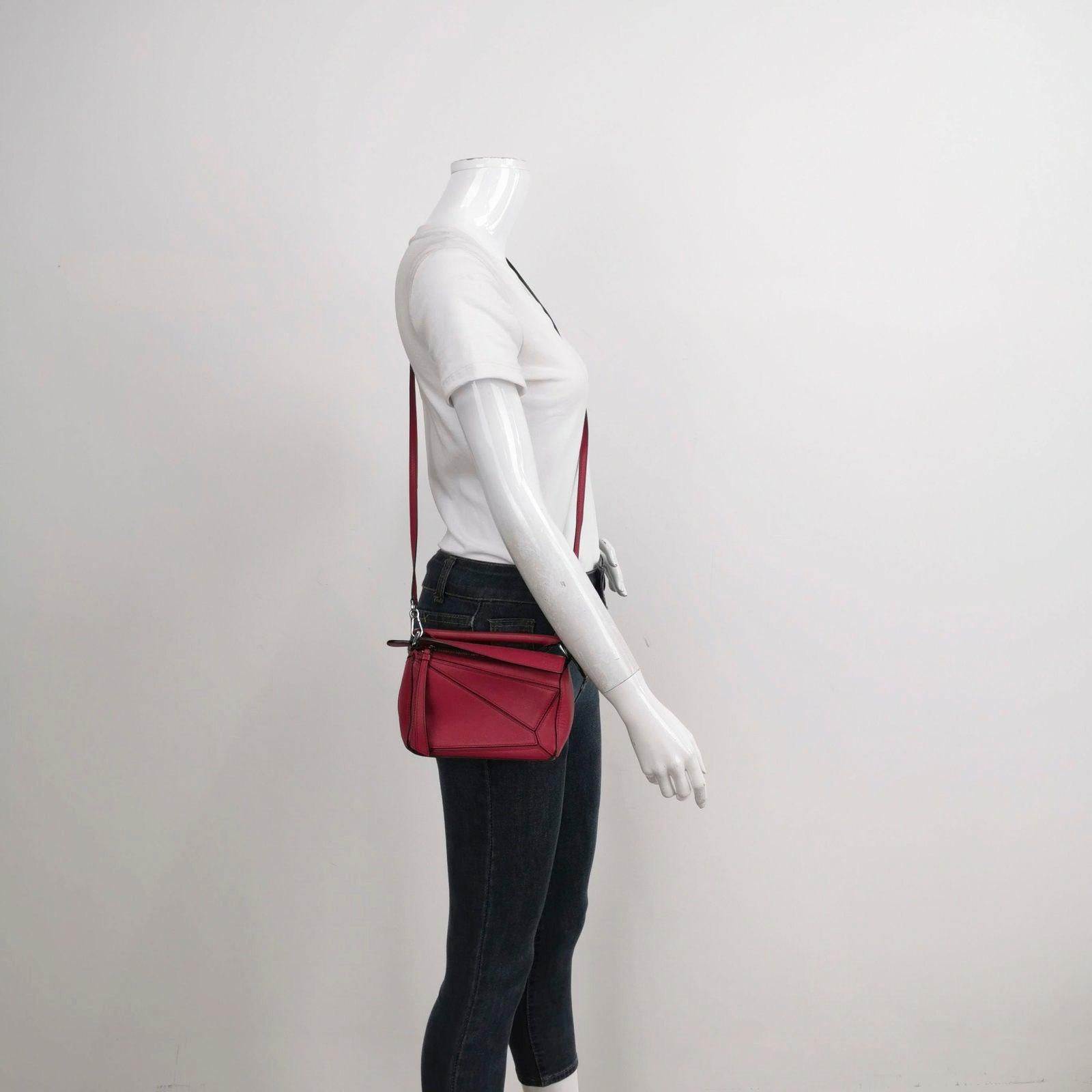 Loewe Puzzle Mini Red Calfskin Leather Crossbody Bag These are professional photos of the actual bag offered by Luxbags. Loewe's Puzzle bag is a timeless classic cult piece. Crafted from supple calfskin leather and finished with silver hardware and