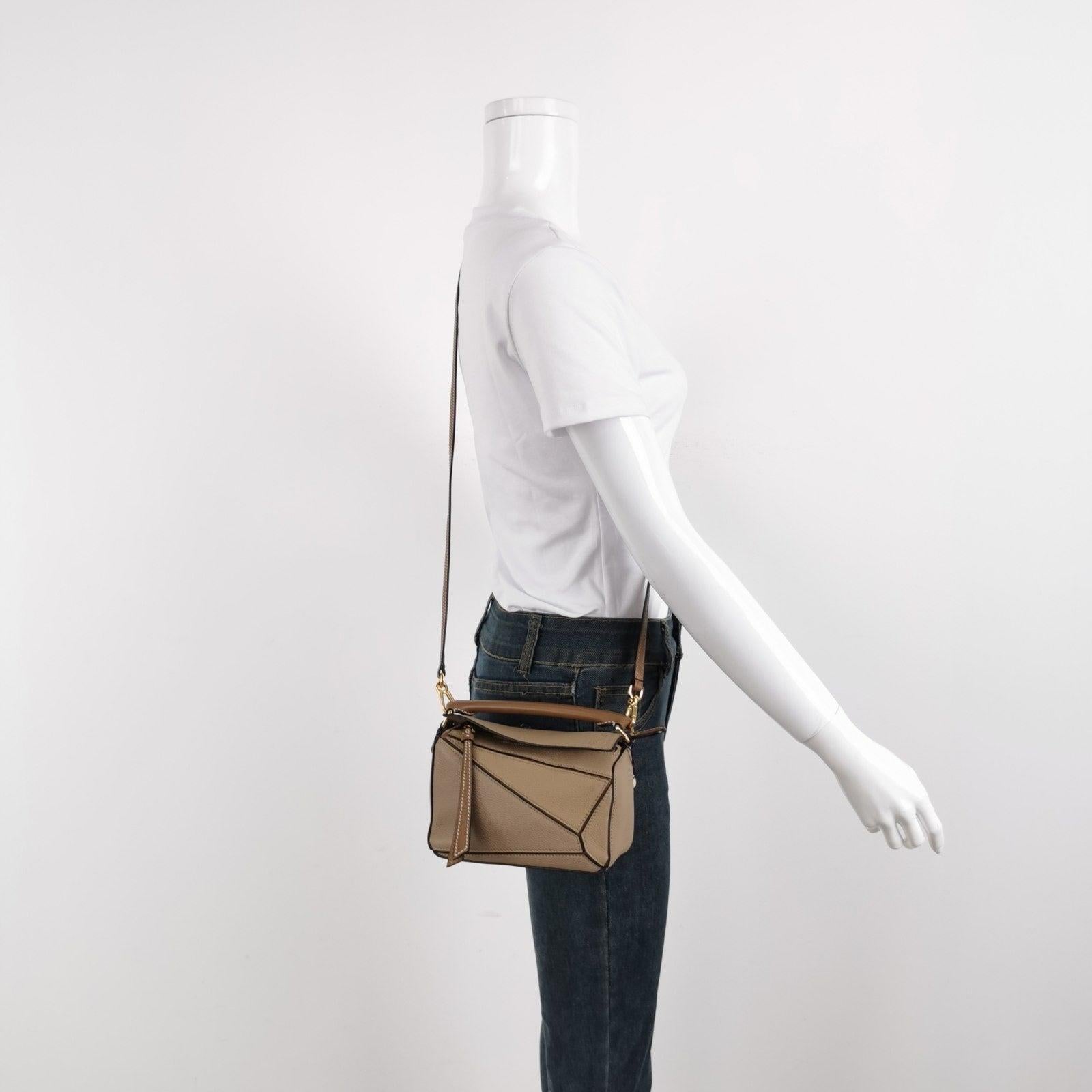 Loewe Puzzle Mini Sandy Beige Calfskin Leather Crossbody Bag
These are professional photos of the actual bag.
  
  Loewe's Puzzle bag is a timeless classic cult piece. Crafted from supple calfskin leather and finished with silver hardware and