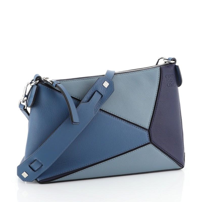 This Loewe Puzzle Pochette Bag Leather Mini, crafted in blue leather, features detachable strap and zip pocket. Its top zip closure opens to a neutral fabric interior with slip pockets.

Estimated Retail Price: $1,350
Condition: Great. Slight
