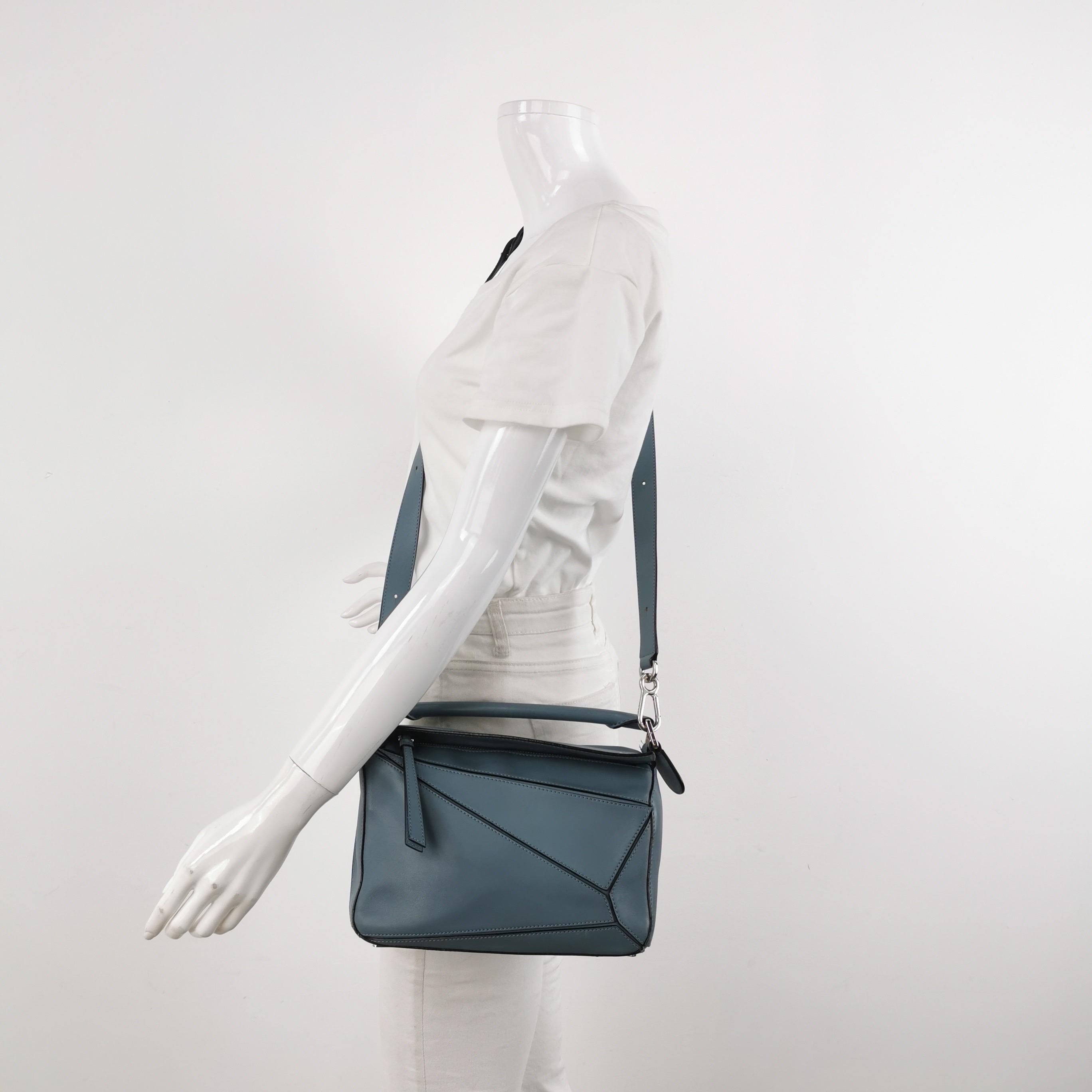 Loewe's Puzzle bag is a timeless classic cult piece. Crafted from supple calfskin leather and finished with silver hardware and signature origami-inspired panels, this bag is versatile and stylish. 

CONDITION: VERY GOOD 

This preloved item is in