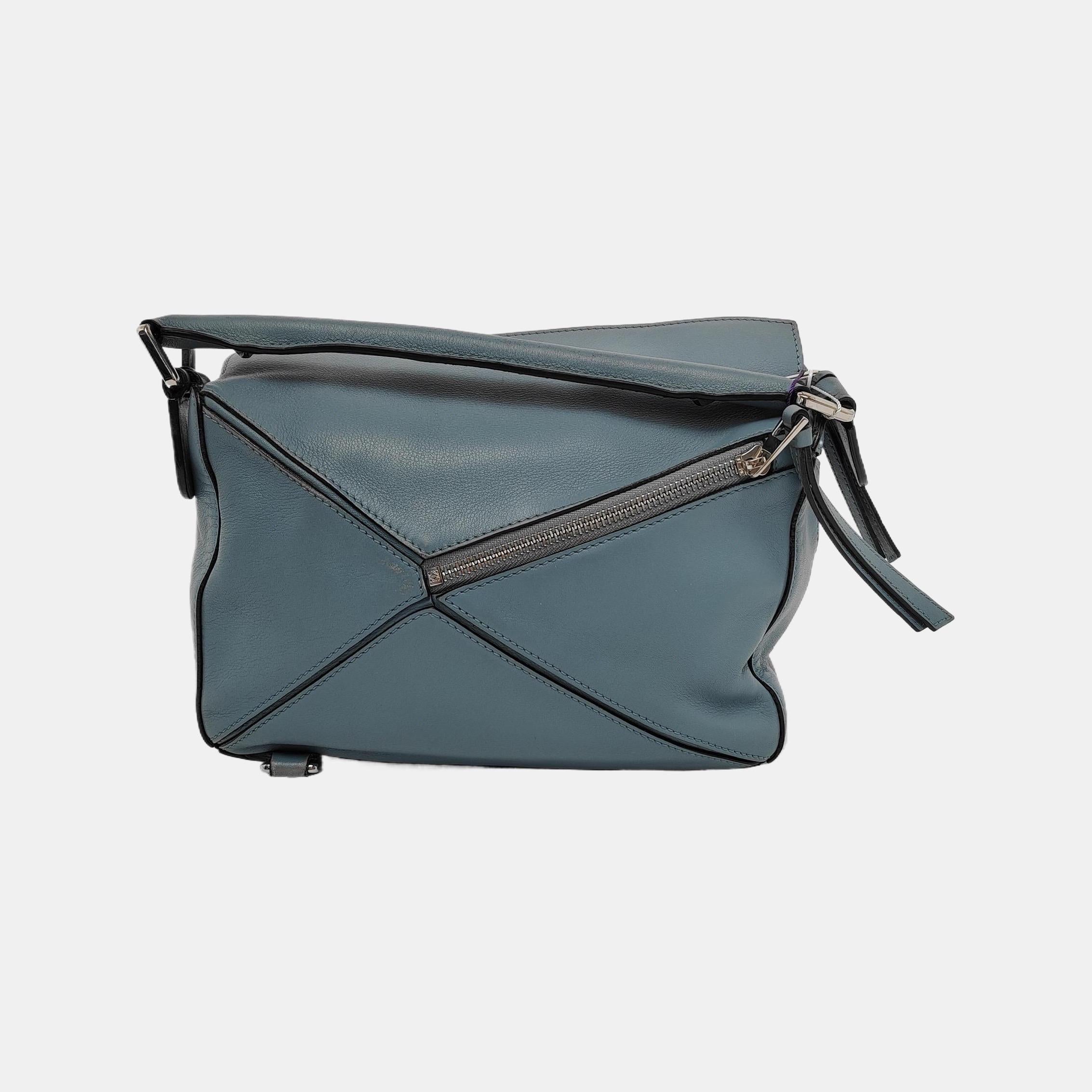 Loewe's Puzzle bag is a timeless classic cult piece. Crafted from supple calfskin leather and finished with silver hardware and signature origami-inspired panels, this bag is versatile and stylish. 

CONDITION: GOOD 

This preloved item is in good