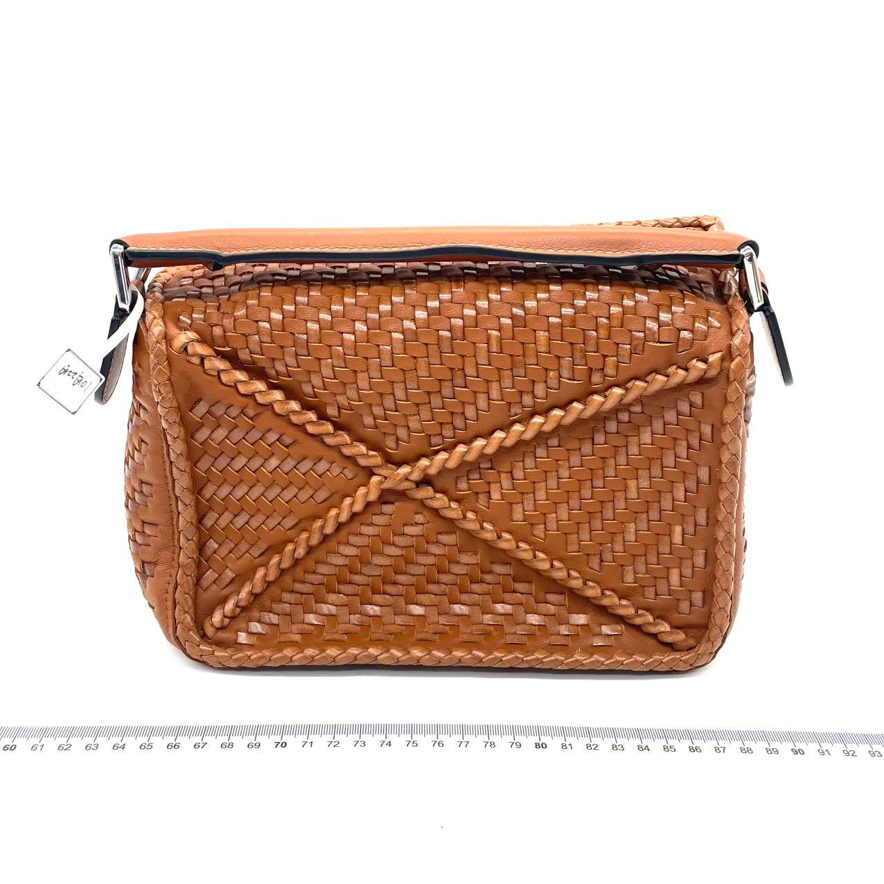 Loewe Puzzle Kleine geflochtene Ledertasche Braun Crossbody Tasche
Dies sind professionelle Fotos der tatsächlich von Luxbags angebotenen Tasche.

Diese Crossbody-Tasche wurde fachmännisch aus hochwertigem Kalbsleder gefertigt und sorgfältig aus