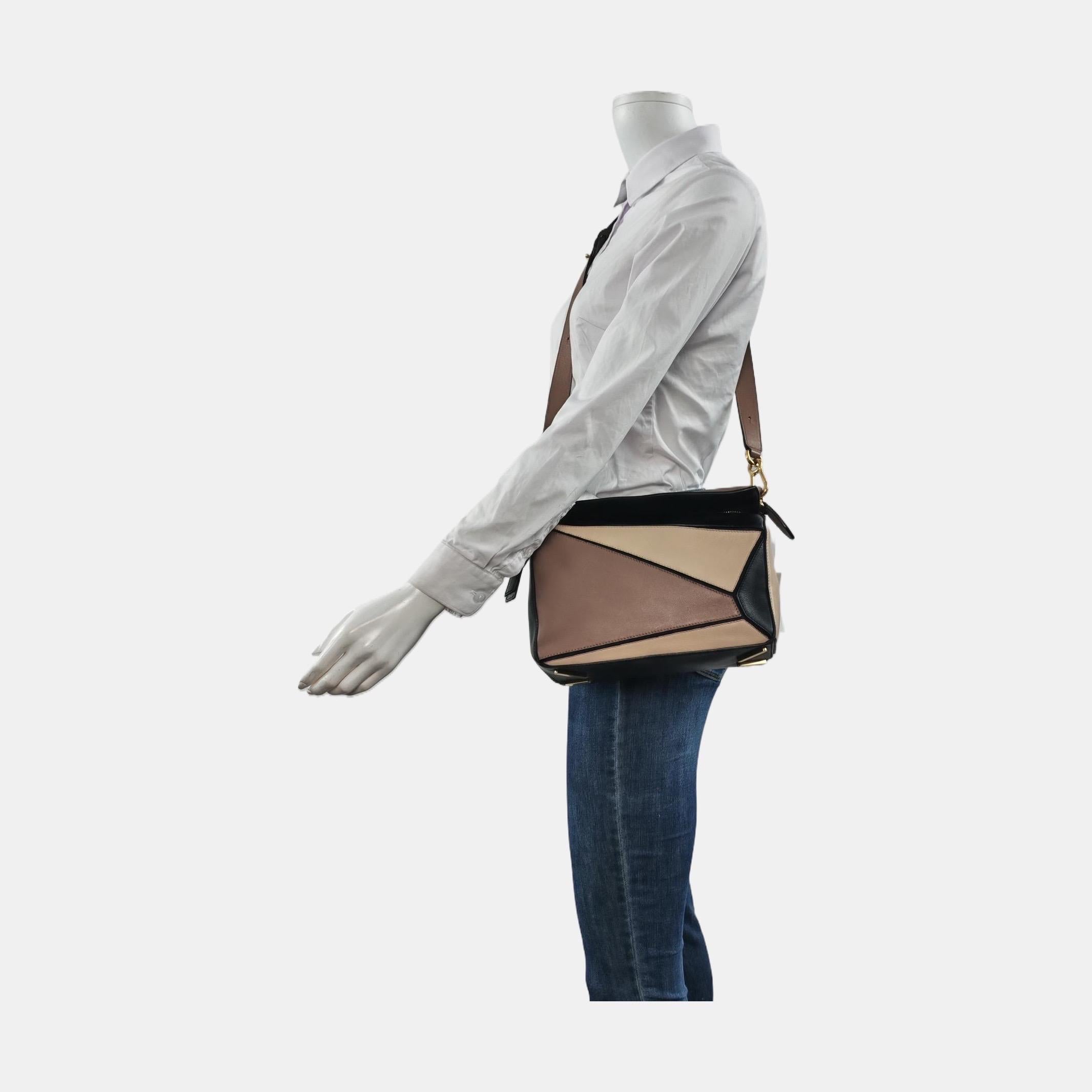 Loewe's Puzzle bag is a timeless classic cult piece. Crafted from supple calfskin leather and finished with silver hardware and signature origami-inspired panels, this bag is versatile and stylish. 

CONDITION: VERY GOOD 

This preloved item is in