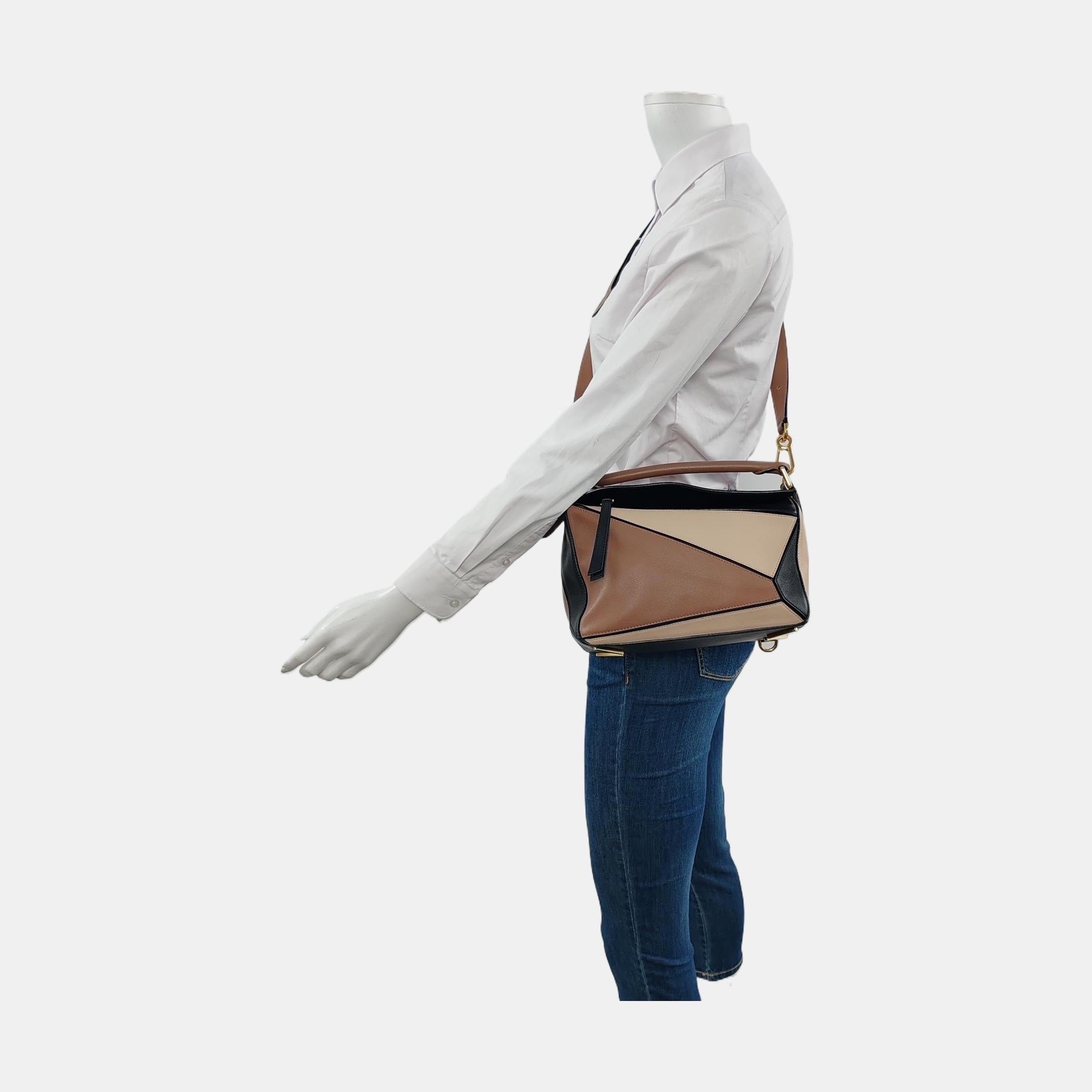 Loewe's Puzzle bag is a timeless classic cult piece. Crafted from supple calfskin leather and finished with silver hardware and signature origami-inspired panels, this bag is versatile and stylish. 

CONDITION: VERY GOOD 

This preloved item is in