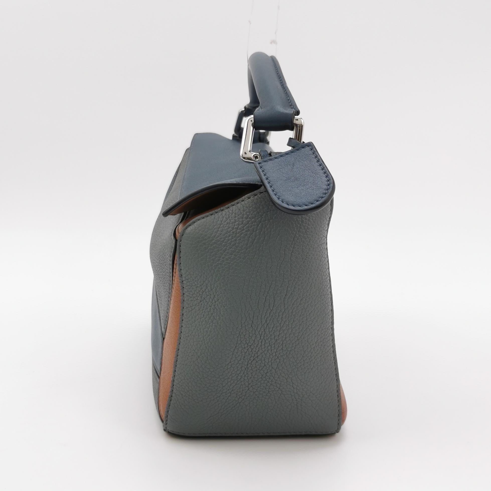 Loewe's Puzzle bag is a timeless classic cult piece. Crafted from supple calfskin leather and finished with silver hardware and signature origami-inspired panels, this bag is versatile and stylish.

CONDITION: VERY GOOD

This preloved item is in