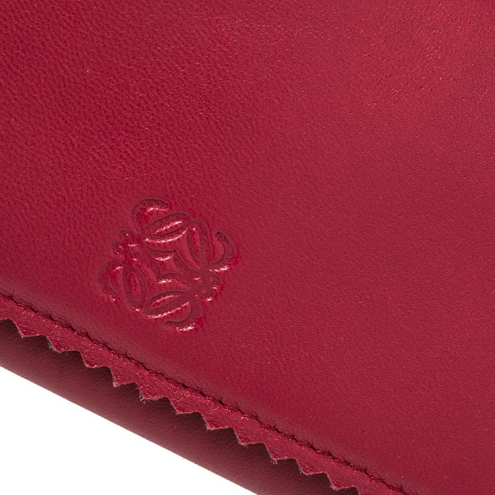 This continental wallet from Loewe has been meticulously crafted from red leather. The front flap opens to reveal a leather and fabric-lined interior that houses multiple card slots, two open compartments, and one zip pocket. This piece is complete