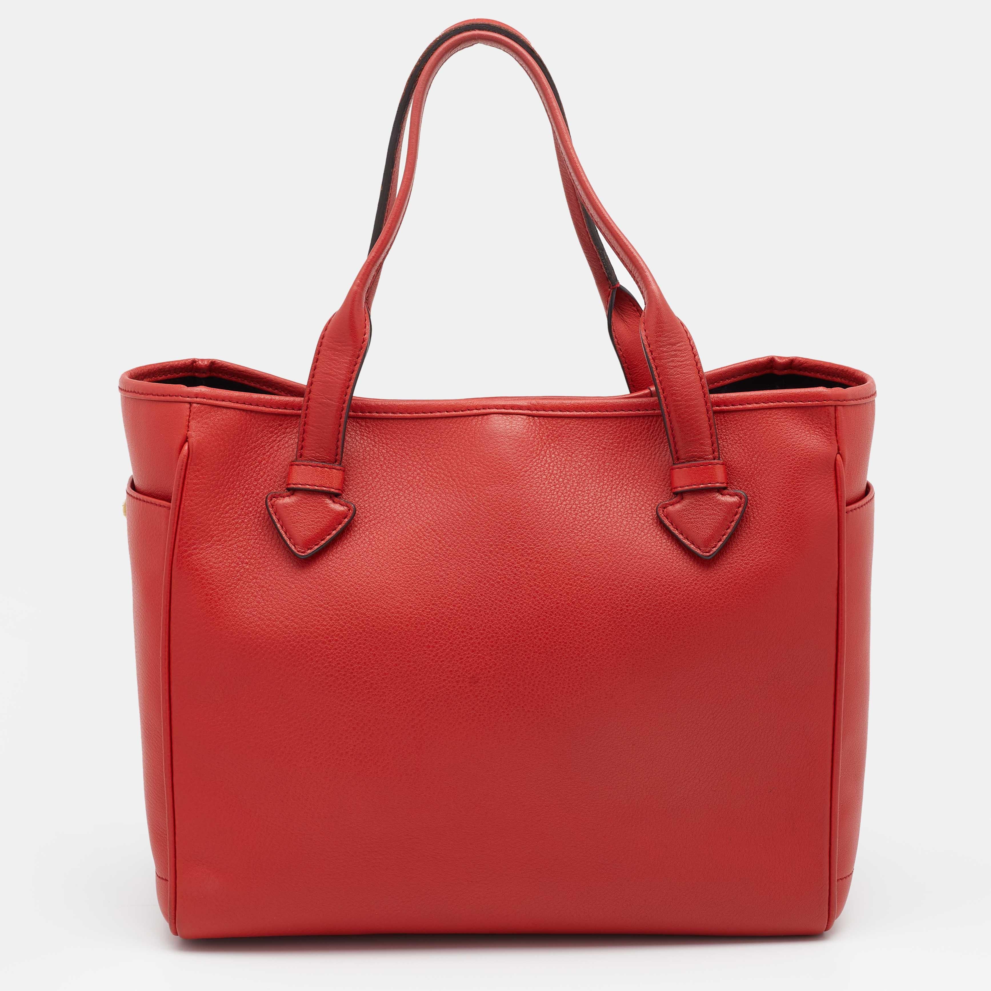 Handbags are more than just instruments to carry one's essentials. Loewe brings you this gorgeous Heritage tote to elevate your style. It is created using red leather on the exterior and features two handles, a spacious interior, and gold-tone