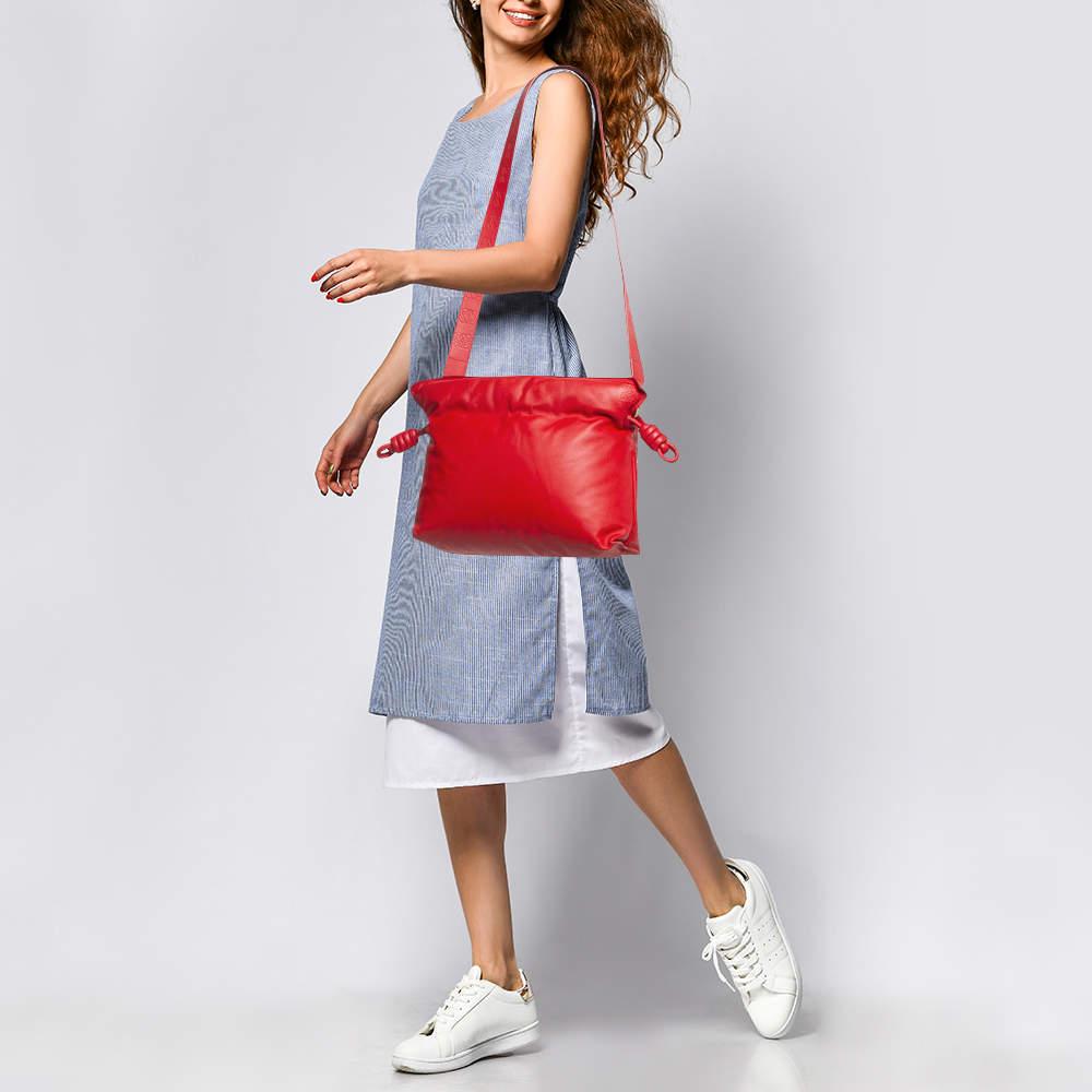 Design/One minimal  ce sac Loewe Flamenco est aussi élégant que pratique. Créé en cuir  Il est maintenu par une bandoulière et la signature de la marque sur le devant lui confère une touche d'exclusivité. L'intérieur doublé de tissu offre