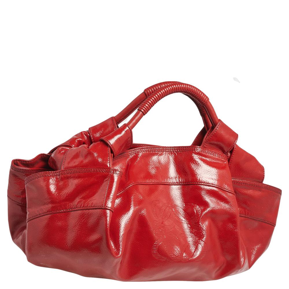 Simple yet luxurious in design, this hobo from Loewe definitely needs to be in your closet. The red hobo is crafted from patent leather in a slouchy structure. It features two handles and a spacious nylon interior to perfectly hold all your daily
