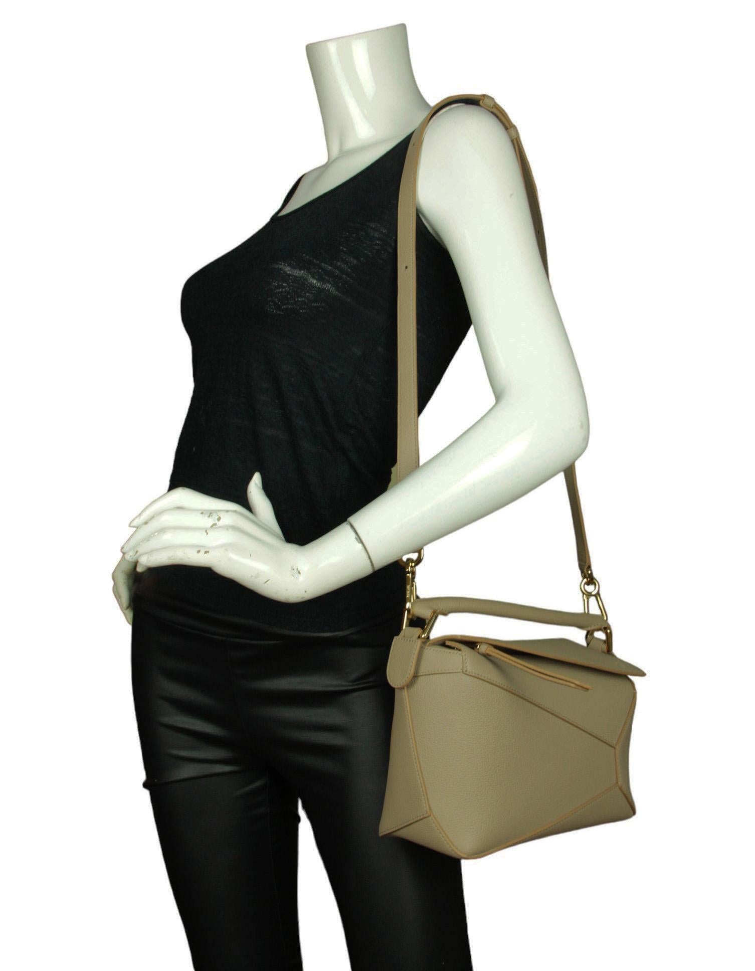 Loewe Sand Beige Soft Grained Calfskin Leather Small Puzzle Bag.  Features optional adjustable shoulder strap. 

Made In: Spain
Color: Sand- taupe beige
Hardware: Goldtone hardware
Materials: Leather 
Lining: Textile
Closure/Opening: Zip