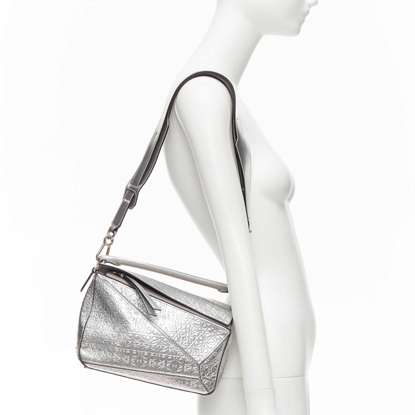 LOEWE Small Puzzle metallic silver calfskin monogram embossed shoulder bag
Reference: NKLL/A00243
Brand: Loewe
Model: Puzzle Small
Material: Leather
Color: Silver, Grey
Pattern: Monogram
Closure: Zip
Lining: Grey Fabric
Extra Details: LOEWE Small