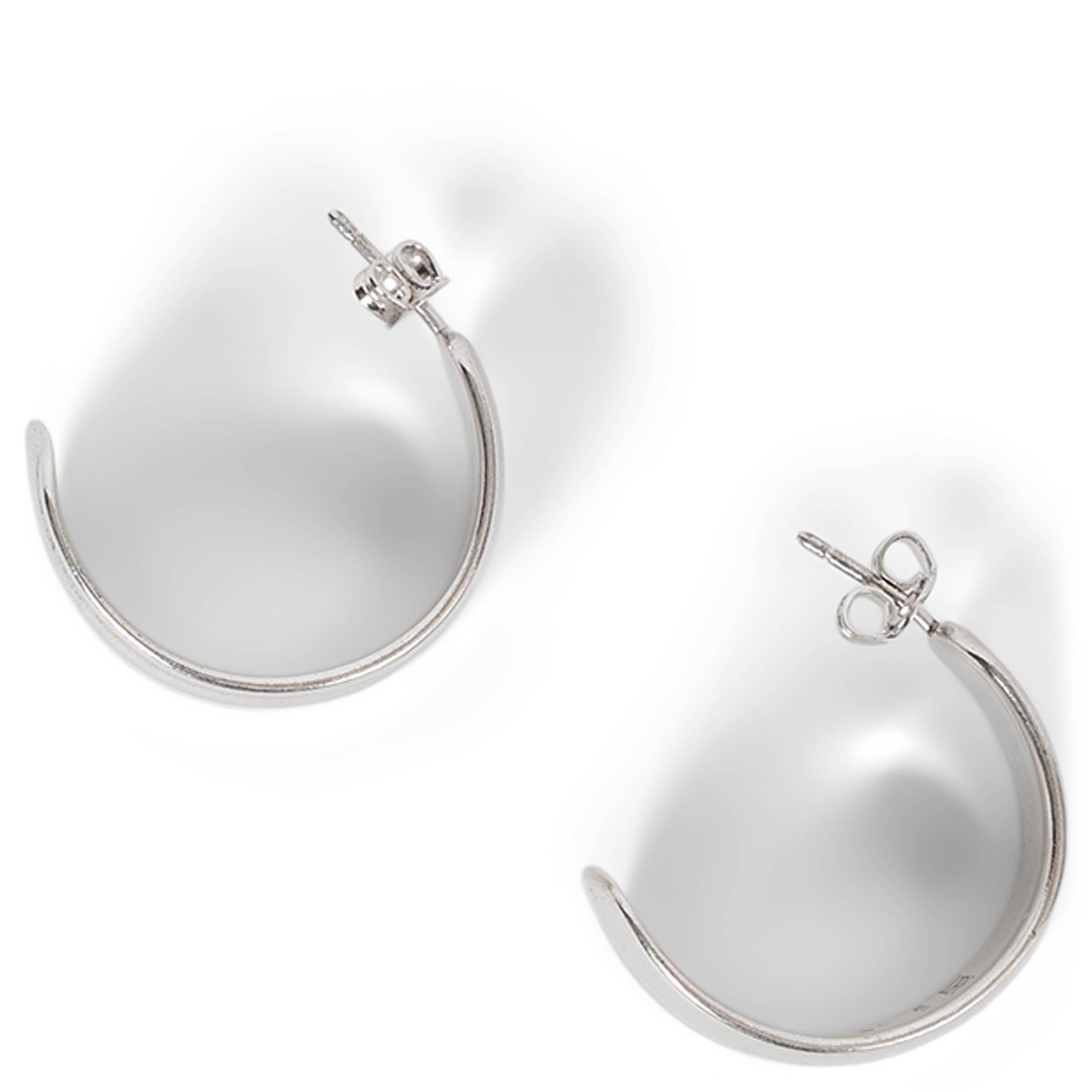 Questi orecchini Loewe Nappa Knot in argento sterling con finitura rodiata, autentici al 100%, offrono un design elegante e moderno. Caratterizzati da una silhouette fluida e scultorea a cerchio parziale, riflettono l'estetica minimalista tipica di