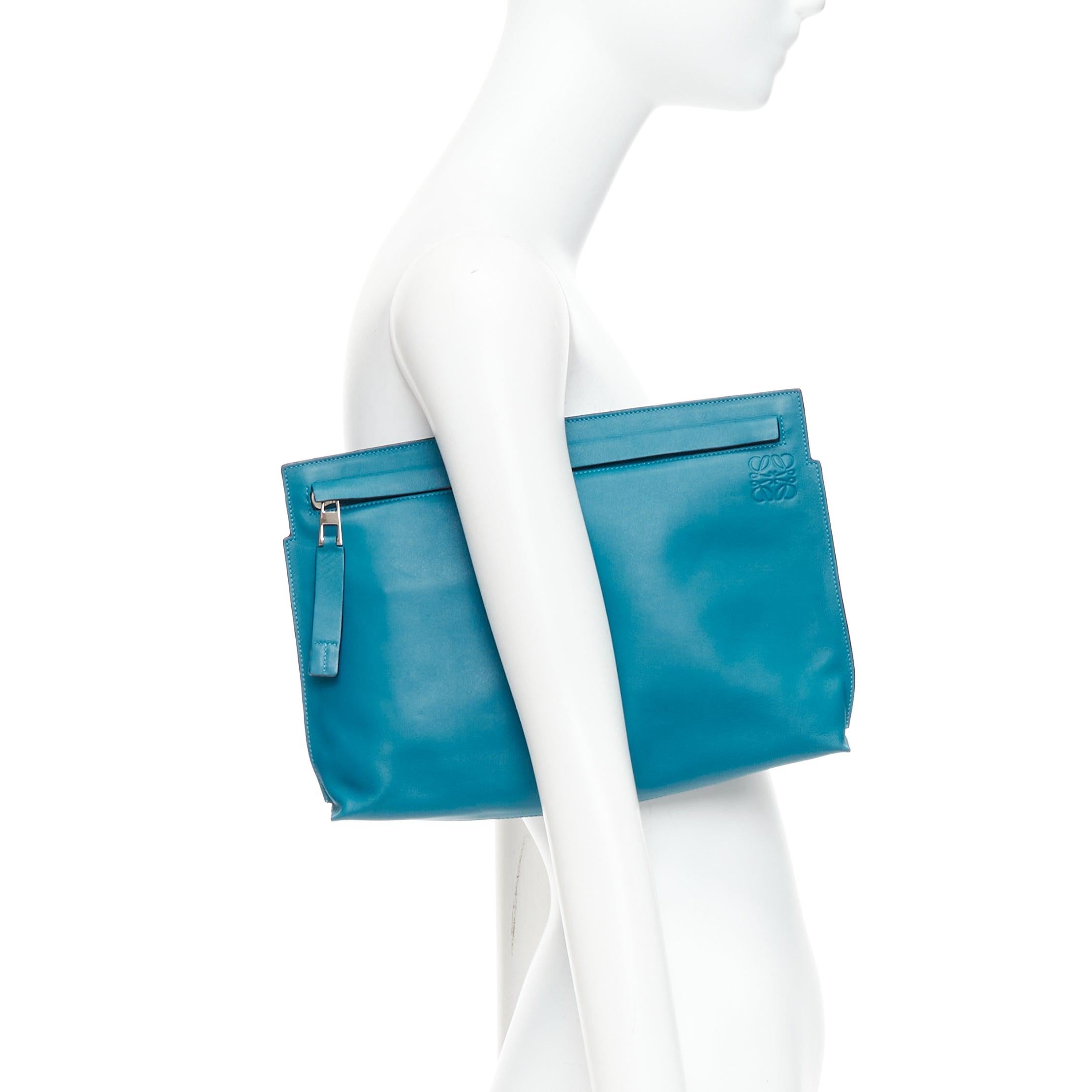 LOEWE T Pouch teal blue soft leather anagram logo zip clutch bag
Reference: NKLL/A00488
Brand: Loewe
Designer: JW Anderson
Model: T Pouch
Material: Leather
Color: Blue, Silver
Pattern: Solid
Closure: Zip
Lining: Cream Fabric
Extra Details: Anagram