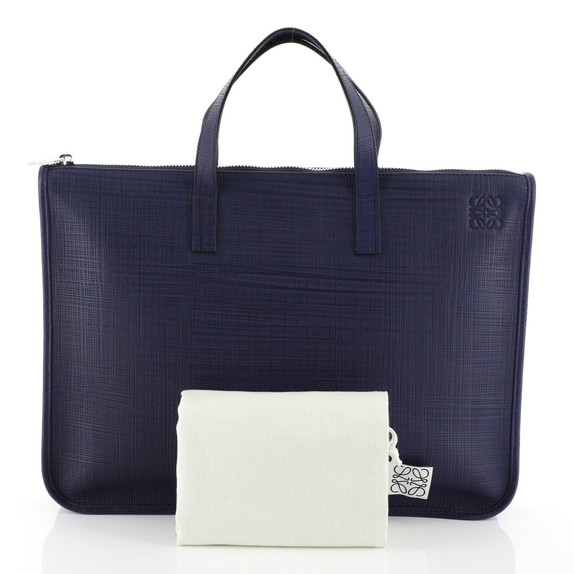 This Loewe Toledo Briefcase Leather Large, crafted from blue leather, features dual top handles and silver-tone hardware. Its zip closure opens to a neutral fabric interior with zip and slip pockets. 

Estimated Retail Price: $1,490
Condition: