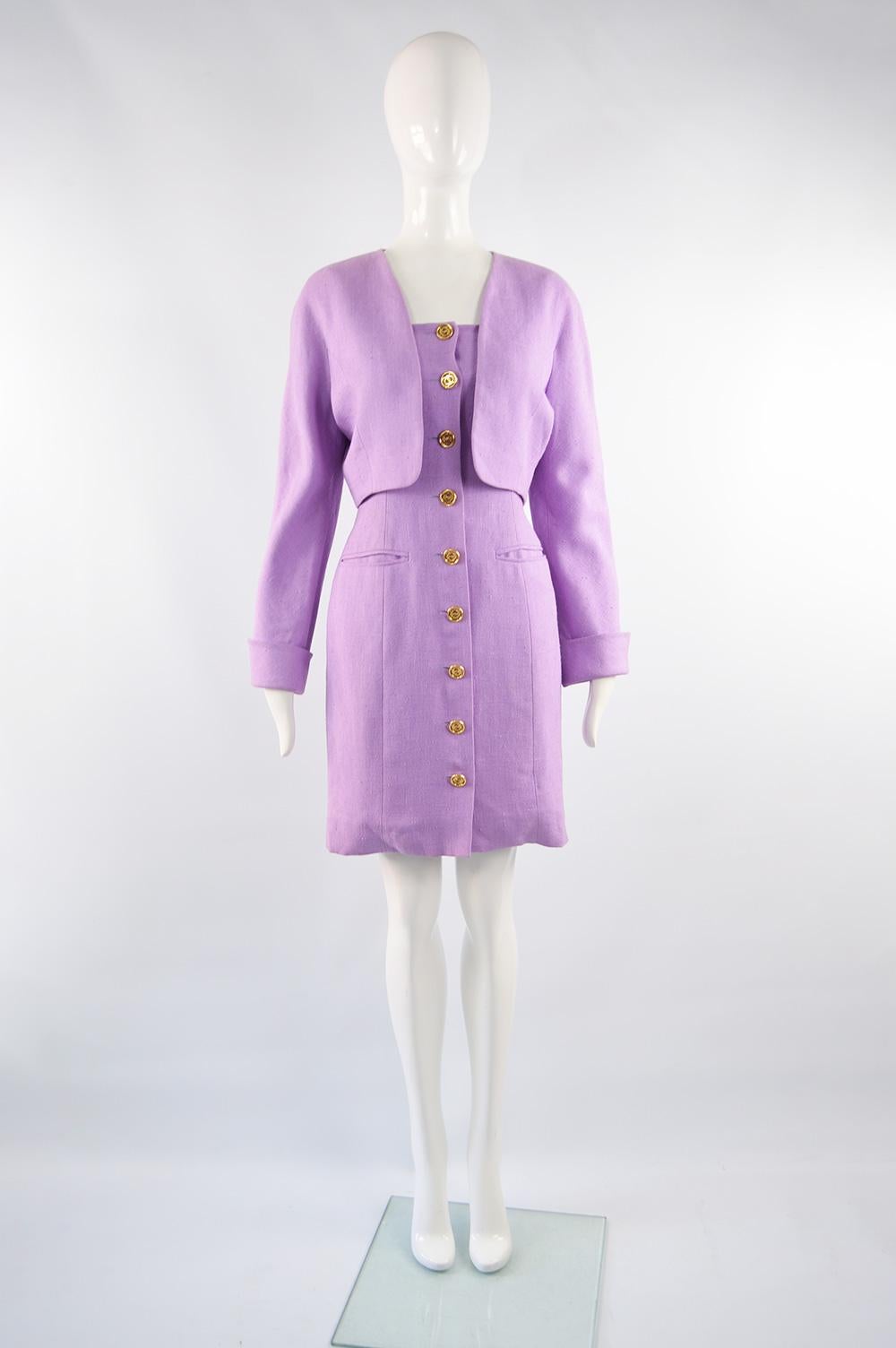 A chic vintage Loewe dress suit from the 80s in a lavender coloured linen with Loewe logo buttons, shoulder pads in the bolero jacket and turn back cuffs. The dress is lightly boned making it perfect for a summer party. 

Size: Marked vintage 40 but