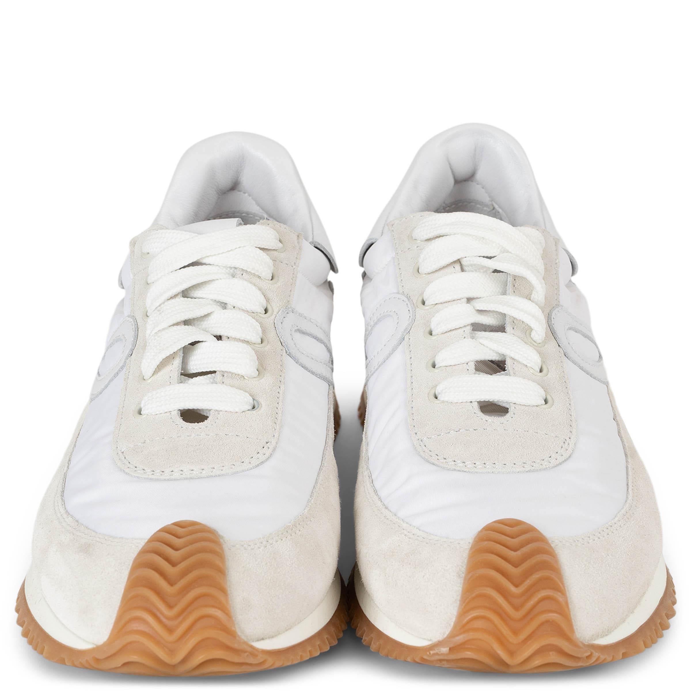 Queste sneakers basse Loewe Flow, autentiche al 100%, in nylon color crema e pelle scamosciata grigio chiaro con dettagli bianchi, riflettono l'estetica moderna e sportiva della casa. Con la punta arrotondata, i lacci bianchi e la suola in gomma
