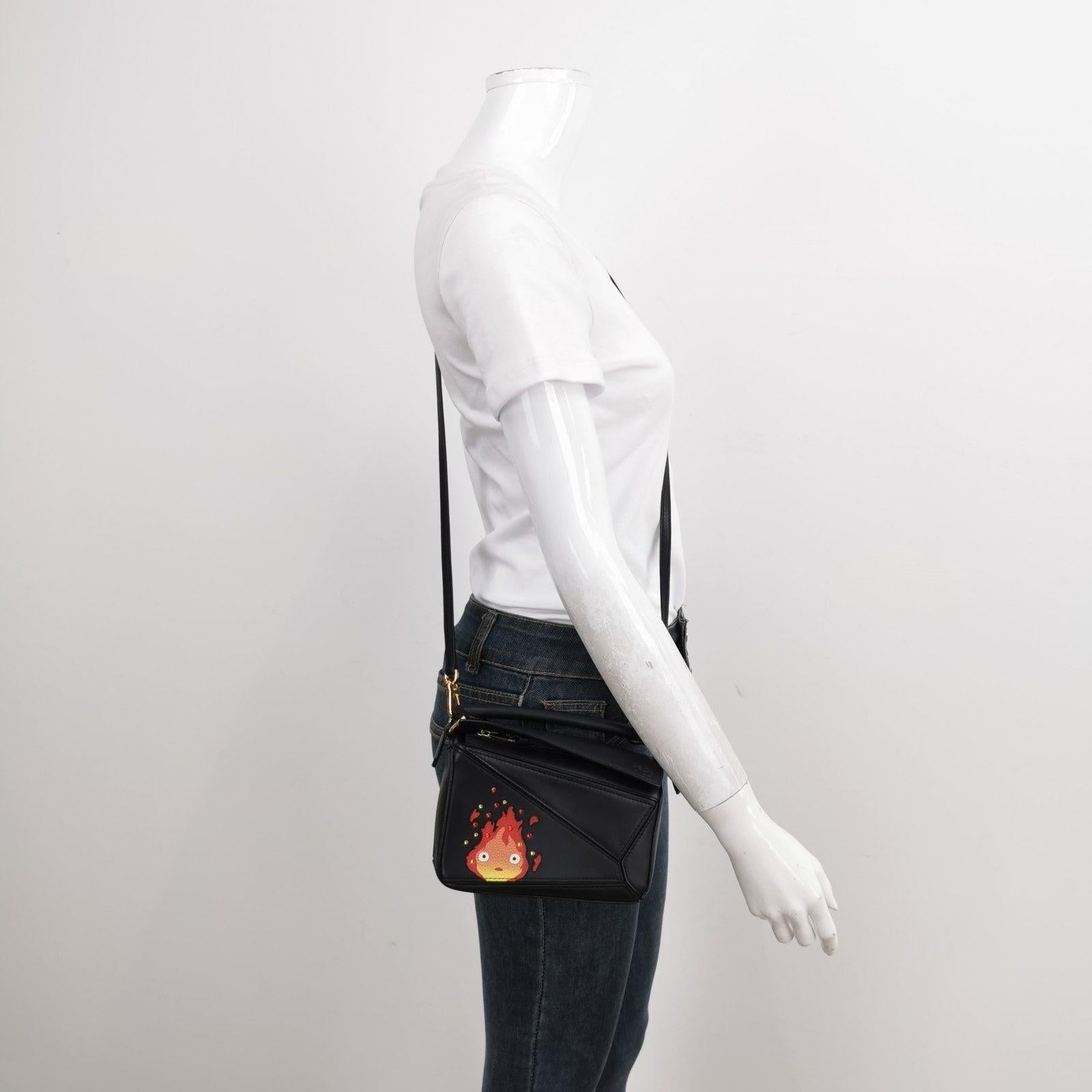 Loewe x Howl's Moving Castle Studio Ghibli Collection Puzzle Calcifer Mini Black Crossbody Bag These are professional photos of the actual bag offered by Luxbags. This is from the sell-out collaboration between Loewe and the Japanese anime studio