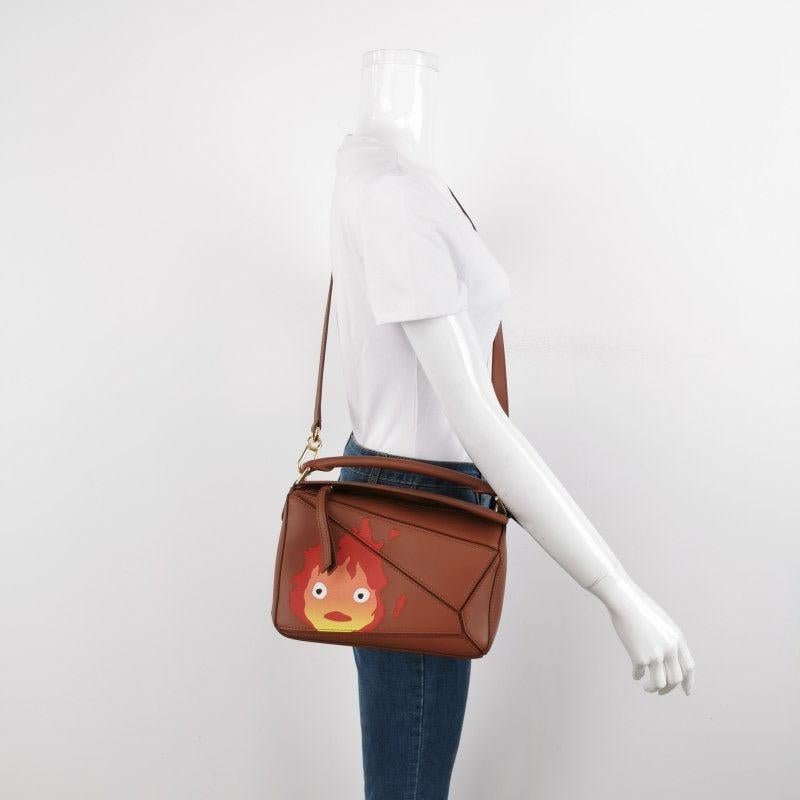 Loewe x Howl's Moving Castle Studio Ghibli Collection Puzzle Calcifer Small Tan Caramel
  Il s'agit de photos professionnelles du sac offert par Luxbags.
  
  Elle est issue de la collaboration à succès entre Loewe et le studio d'animation japonais