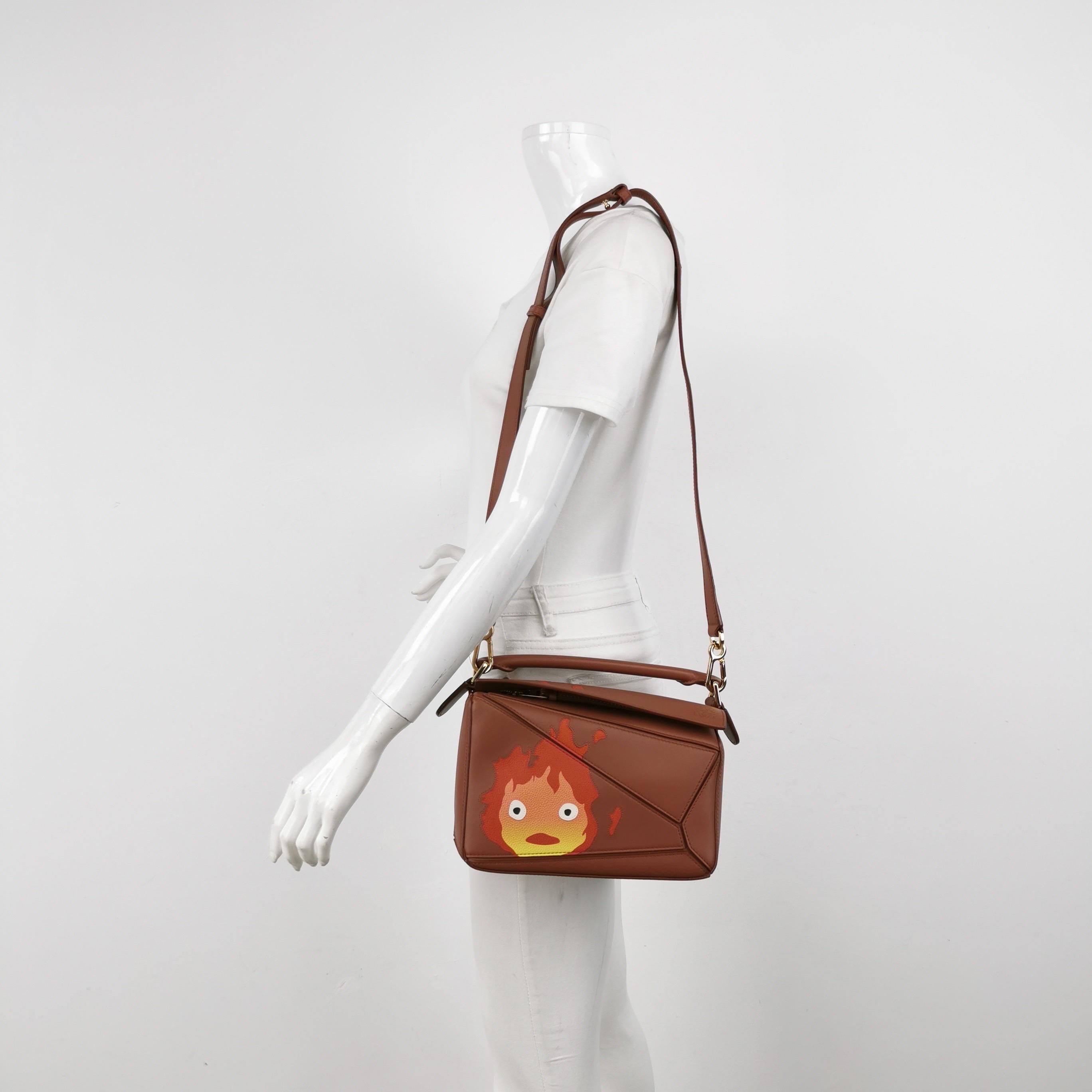 Loewe x Howl's Moving Castle Studio Ghibli Collection'S Puzzle Calcifer Piccolo Tan Caramello
 Queste sono foto professionali della borsa vera e propria.
 
 Questo è il frutto della collaborazione tra Loewe e lo Studio Ghibli del Giappone. Questo