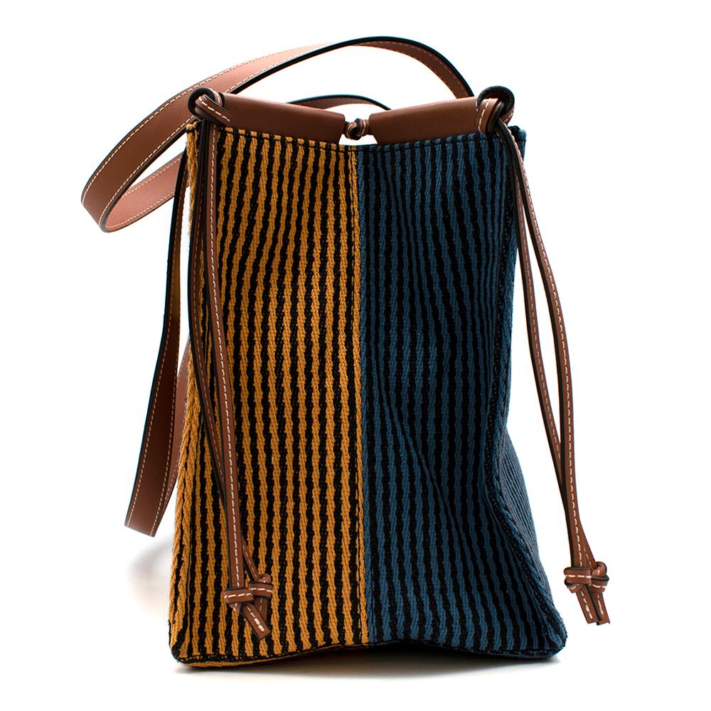 Loewe x Paula's Ibiza Cushion Tote Bag

- Loewe collaboration with Paula's Ibiza
- Bold nautical stripes
- Double top handles
- Paula's logo applique
- Leather Loewe leather patch
- Bended sides
- Leather knotted straps
- Herringbone canvas
