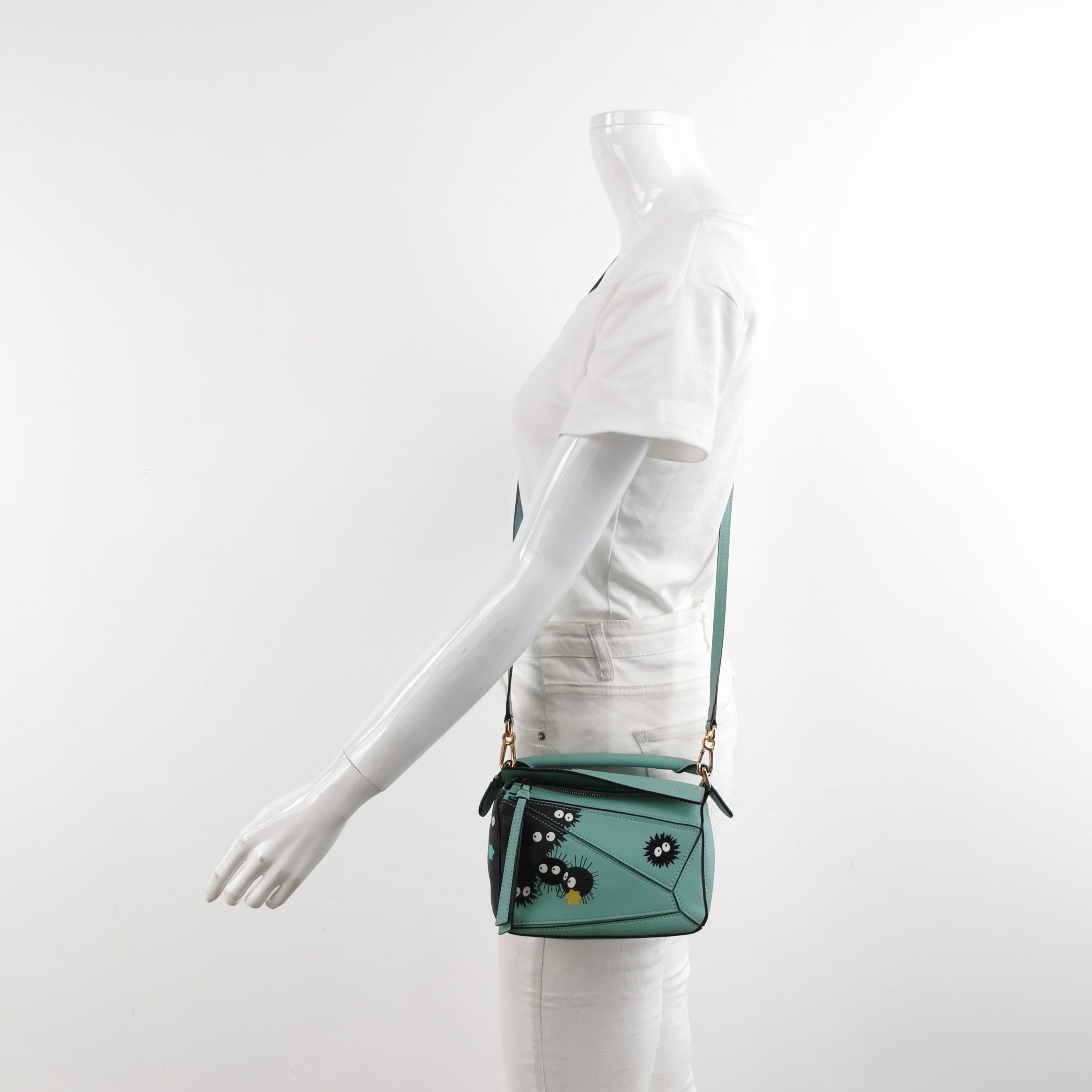This is from the sell-out collaboration between Loewe and the Japanese anime studio Studio Ghibli. This particular mini puzzle bag features a character from the anime Spirited Away, the Susuwatari.

CONDITION: Excellent

Light signs of wear. Light