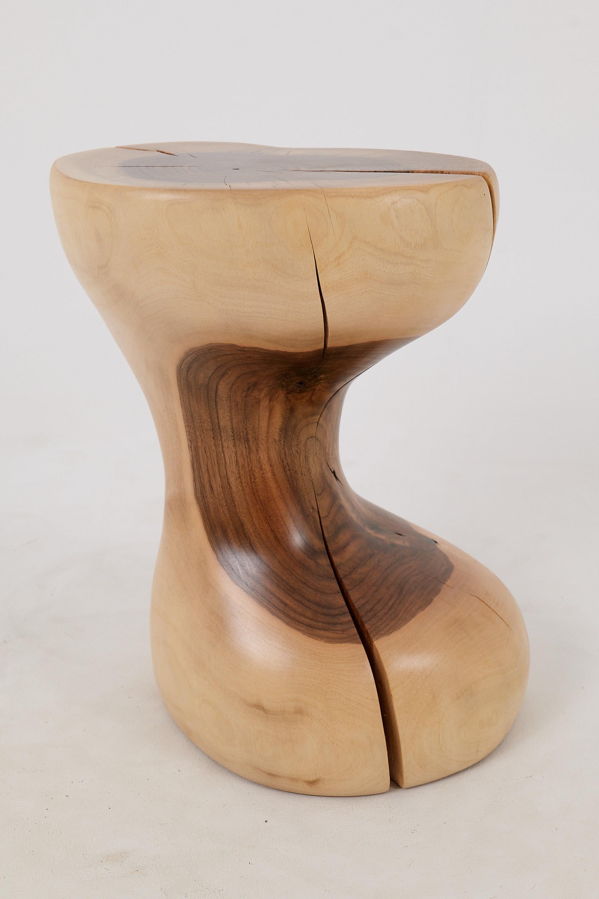 El taburete/mesa auxiliar de nogal hecho a mano ejemplifica la belleza de la artesanía con su diseño elegantemente curvado. Cada curva está meticulosamente moldeada para proporcionar no sólo atractivo estético, sino también comodidad y