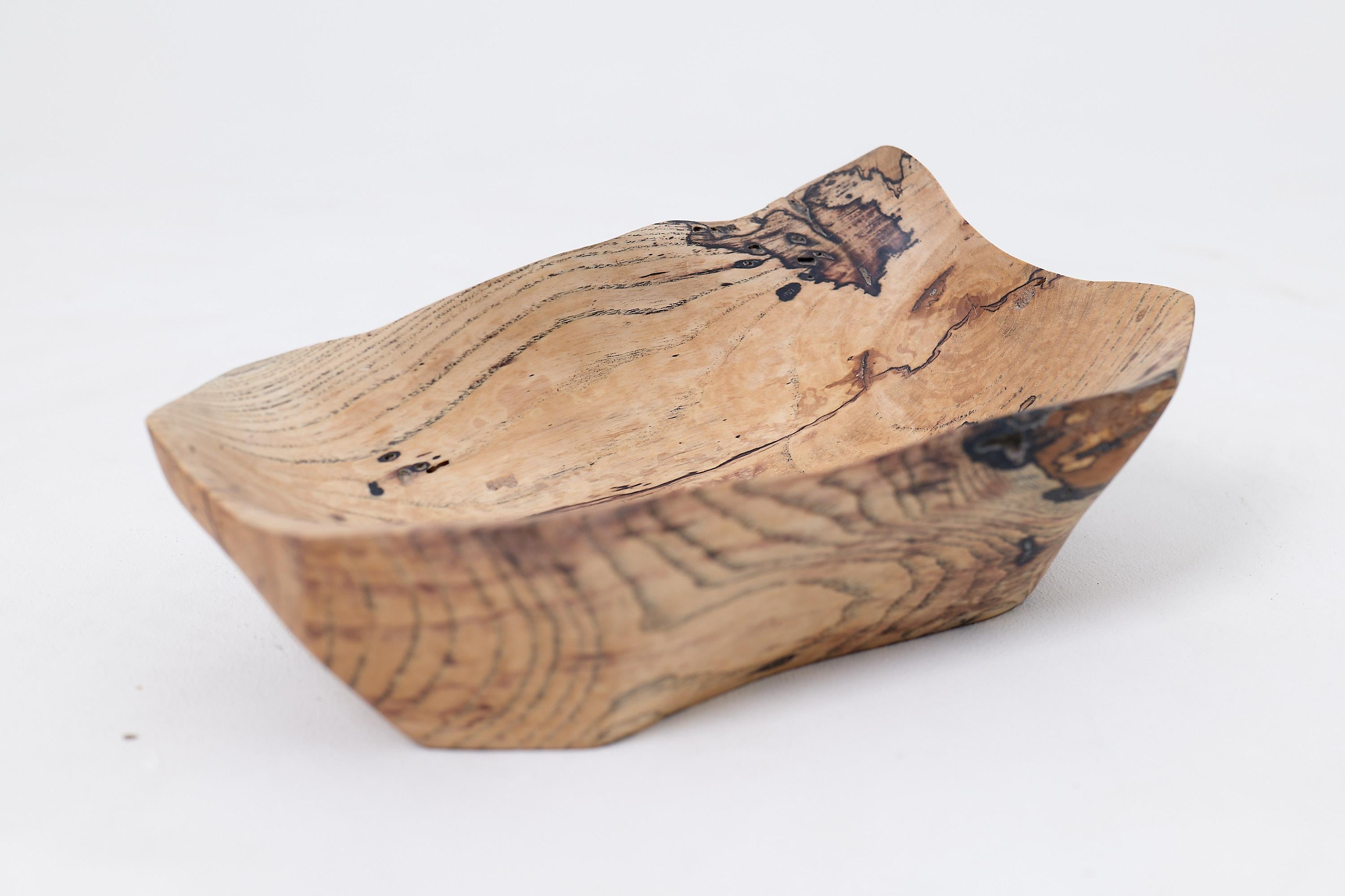 Elevate your home decor with our stunning carved wooden bowl, a true testament to artisanal craftsmanship. This bowl features a gracefully curved shape, making it not only a practical serving piece but also a striking decorative element. Handcrafted