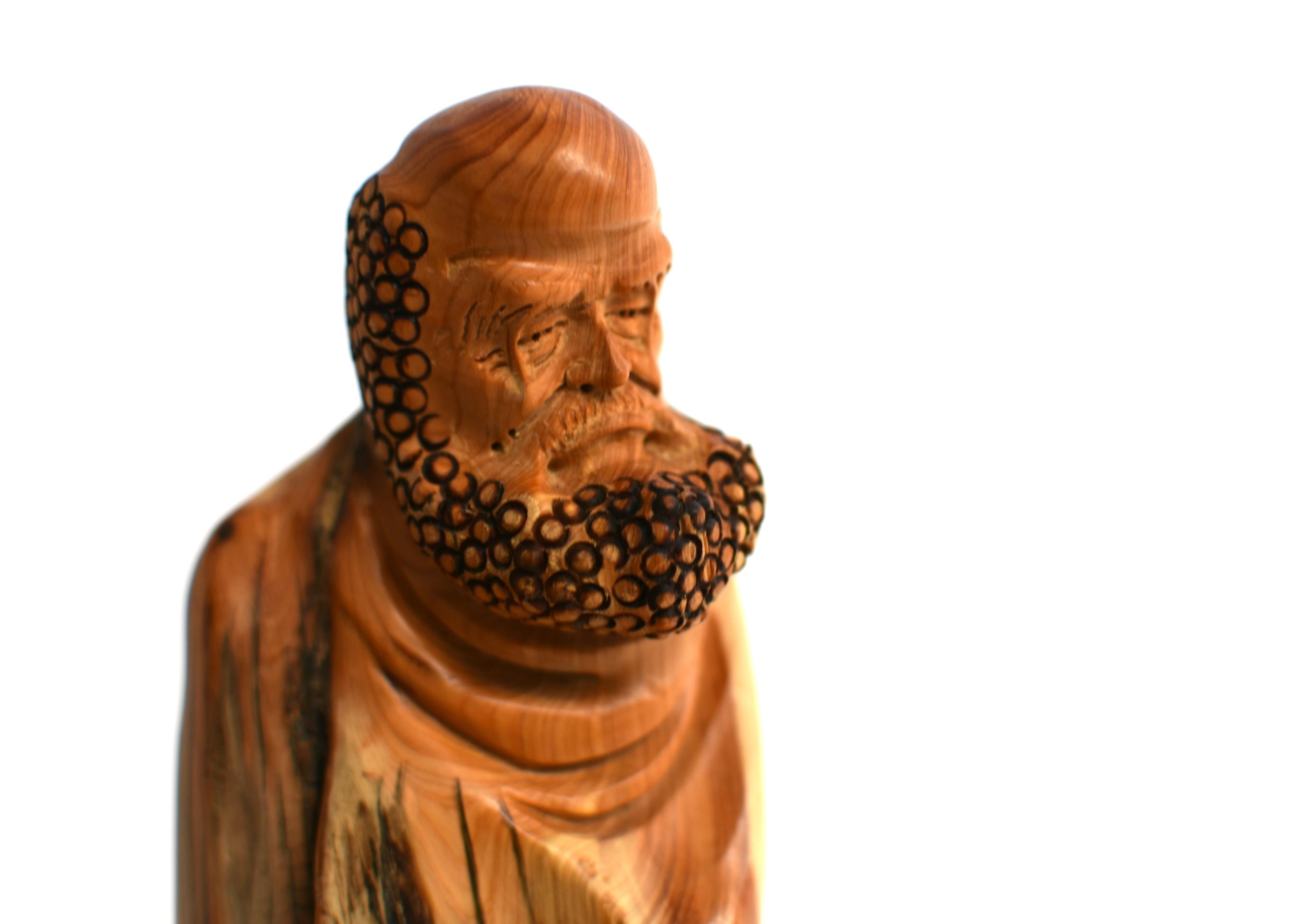 An elegant, hand carved, solid wood sculpture of the Buddhist Arhat (Lohan) 