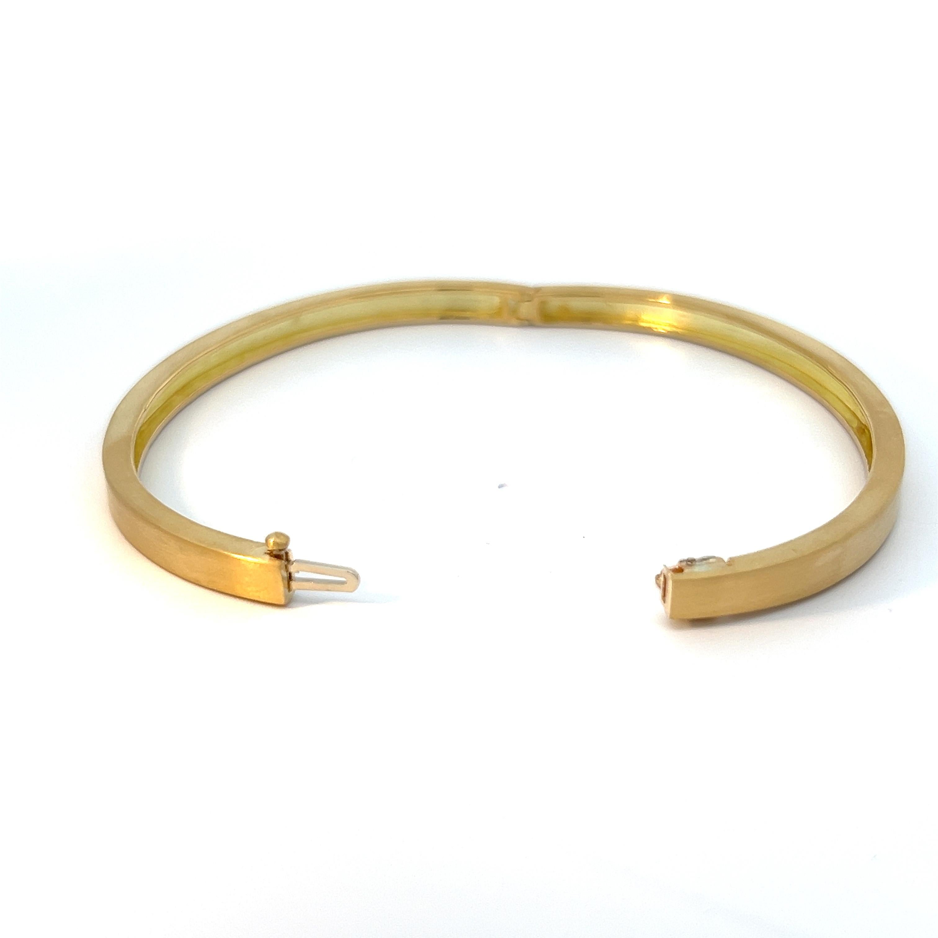 Indulge in understated luxury with this distinguished men's bangle bracelet, meticulously crafted in gleaming 18k yellow gold. The brushed finish lends a subtle yet sophisticated texture to the surface, adding depth and character to this timeless