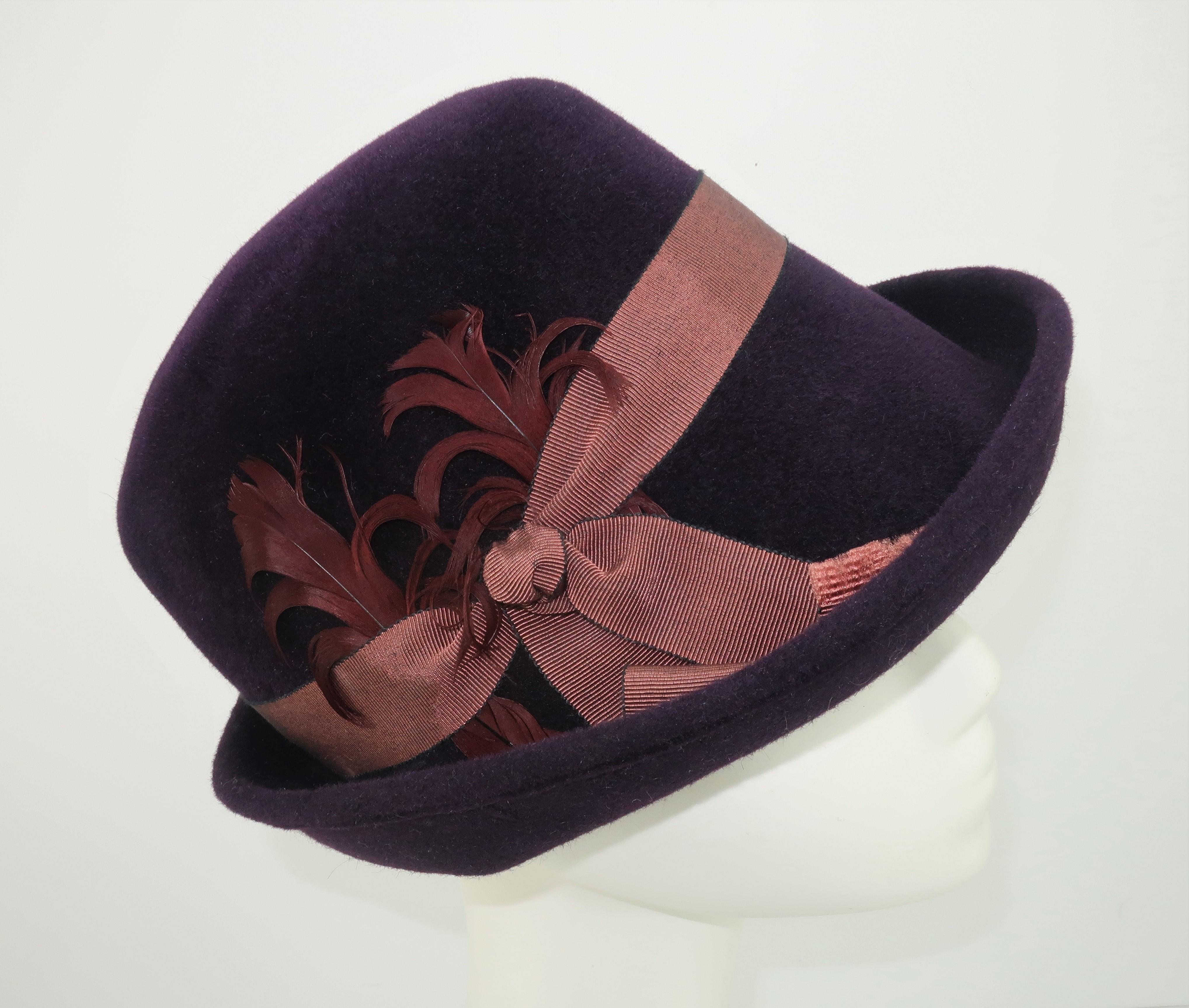 Modern meets old school with this updated wool trilby hat by New York milliner, Lola Ehrlich.  The deep aubergine or plum color is perfectly accented by a grosgrain ribbon and a fan of feathers.
CONDITION
The hat is in good previously owned