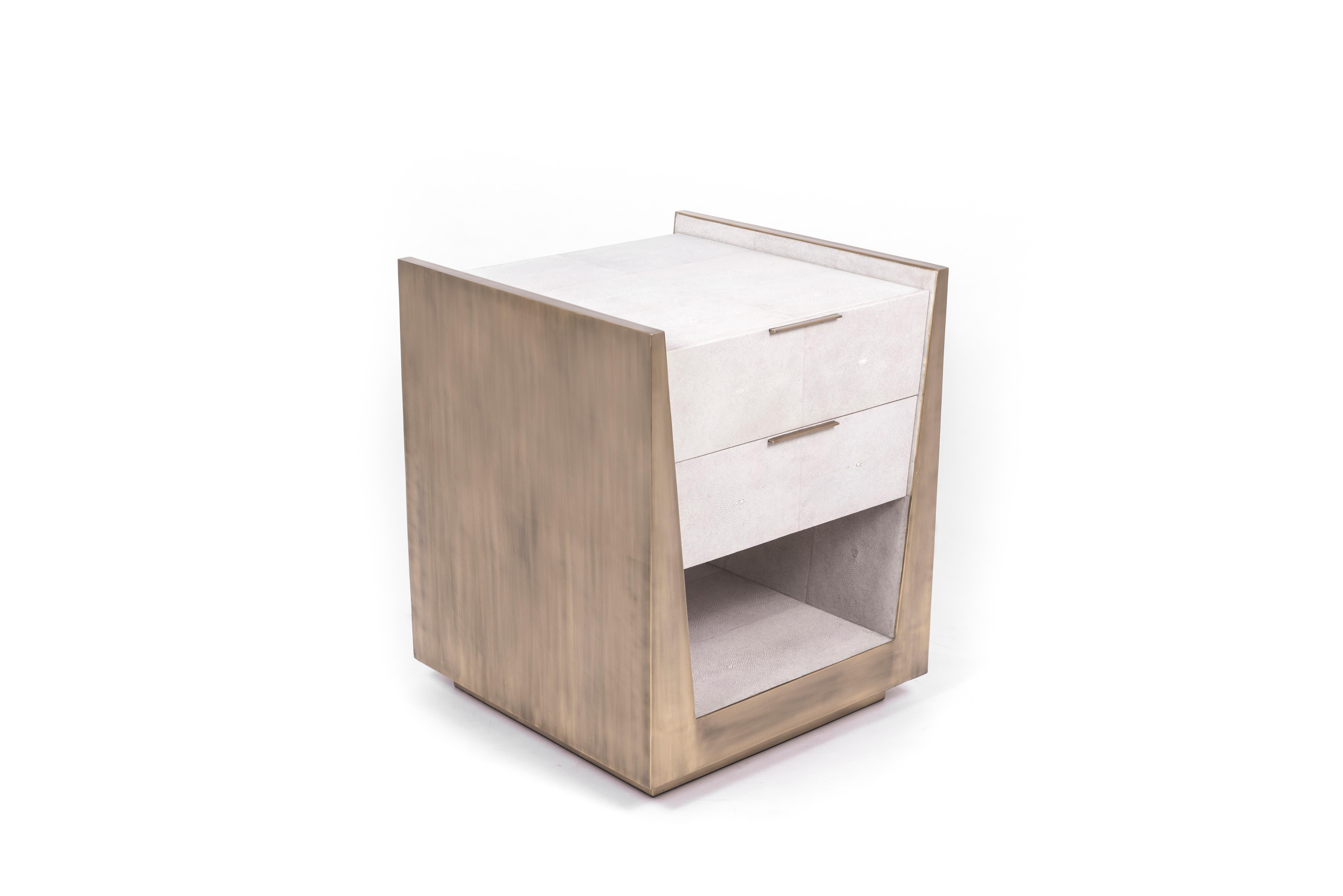 The Lola Bedside by R&Y Augousti is an elegant piece with its subtle geometry. This bedside table is completely inlaid in a mixture of cream shagreen and bronze-patina brass for a luxurious statement. The drawers are inlaid in gemelina wood, with